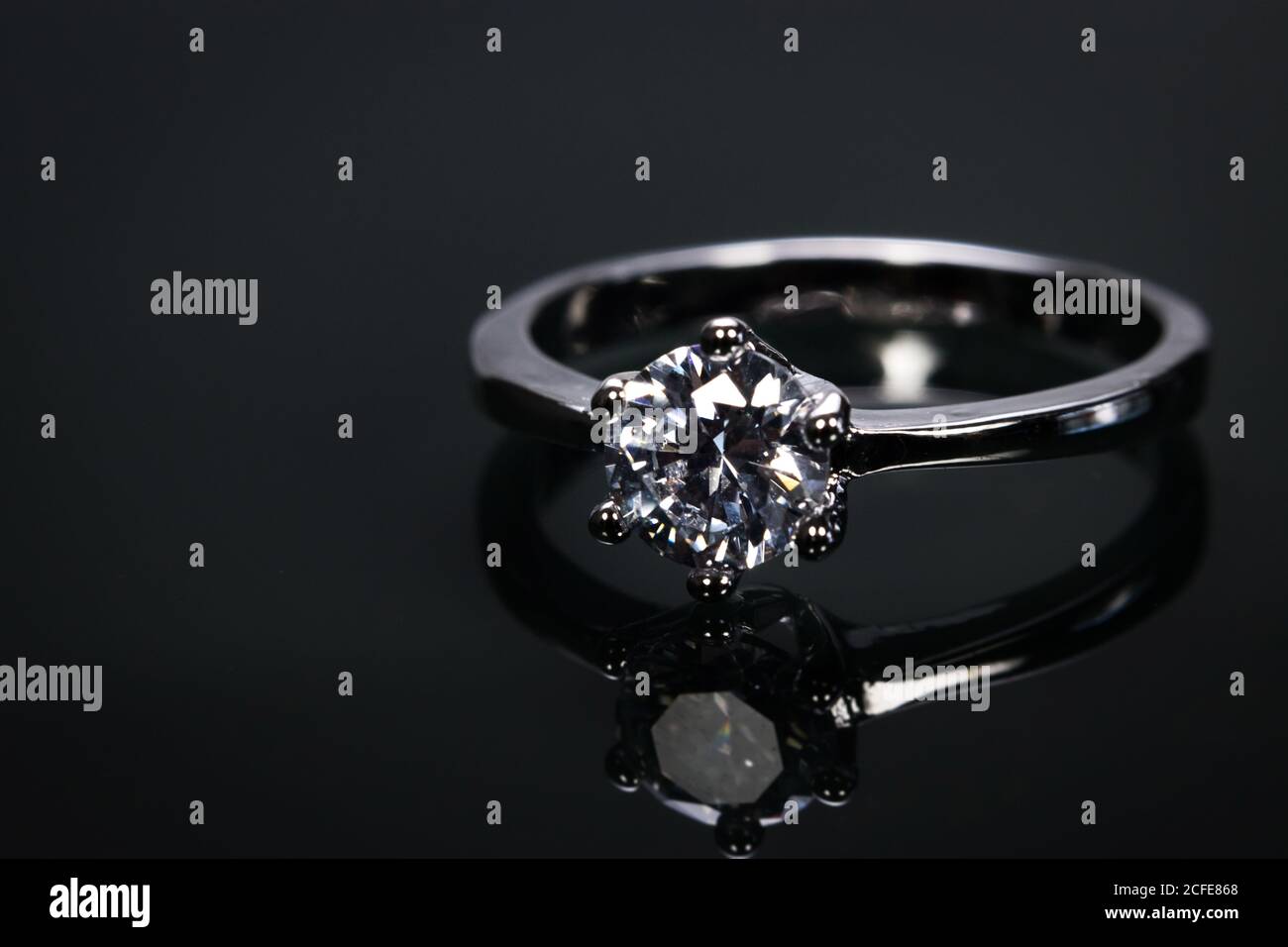 Luxus-Ehering mit großen Diamant-Kristall isoliert auf schwarzem Hintergrund mit Reflect im Spiegel. Stockfoto