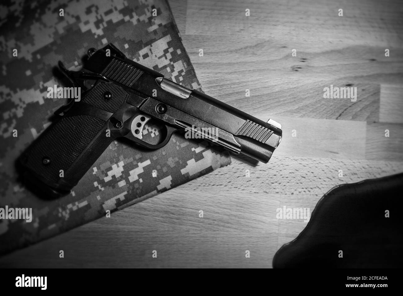 Gewehr und Blut auf Holztisch. Schwarz und weiß. Raub, Mord, Verbrechen und Sicherheitskonzept Stockfoto