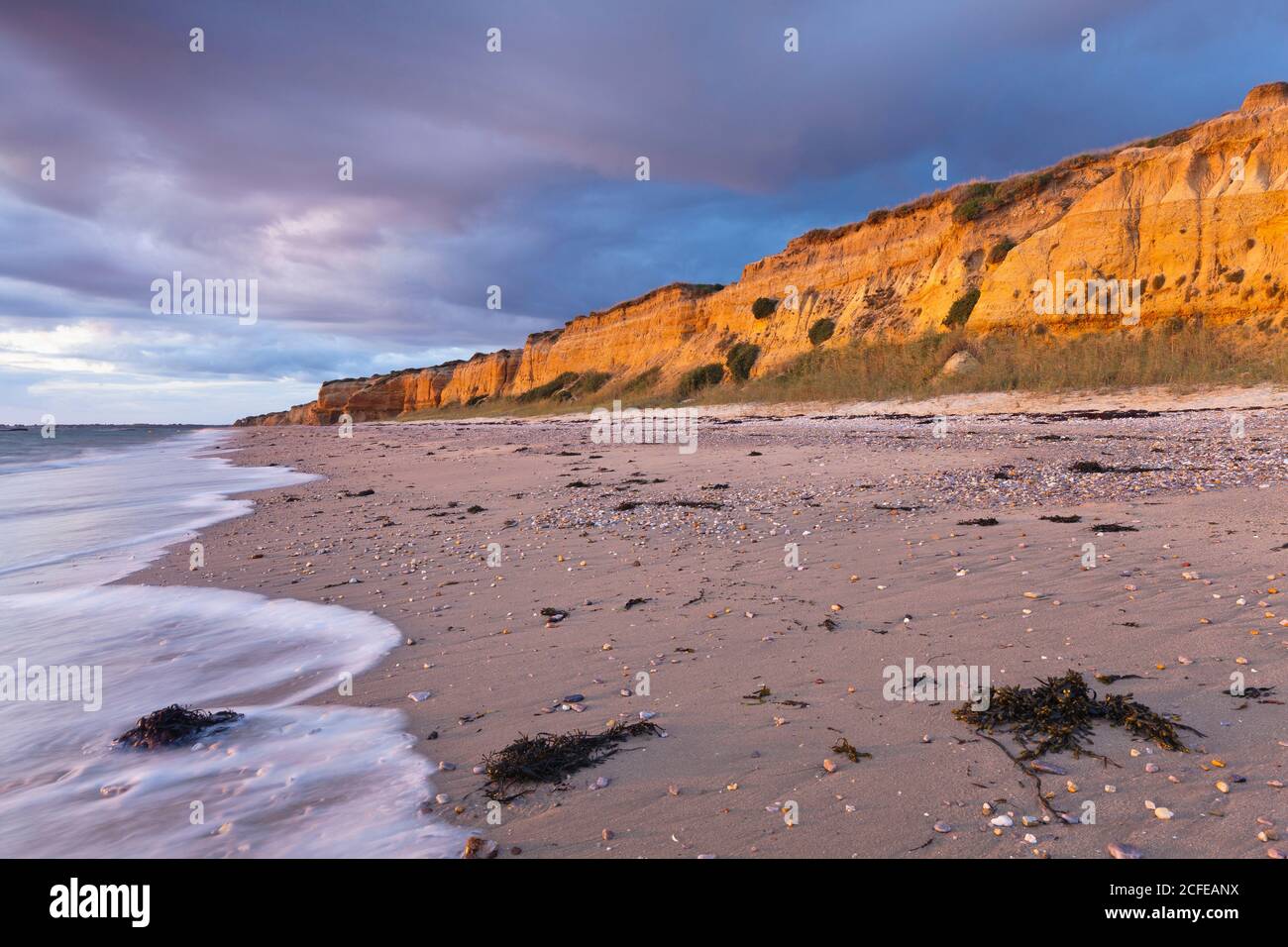 Der Strand von Penestin Plage de la Mine d'Or hat eine ockerfarbene Klippe. Ein Produkt aus Jahrtausende alten Flusslagerstätten. Der Strand liegt im alten Delta Stockfoto