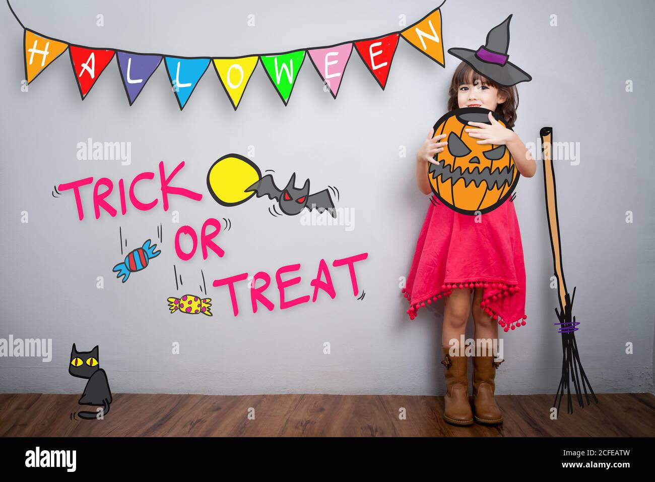 Portrait von niedlichen kleinen Mädchen mit halloween Kostüm Dekoration Thema Mit Trick or Treat Wort im Hintergrund Stockfoto
