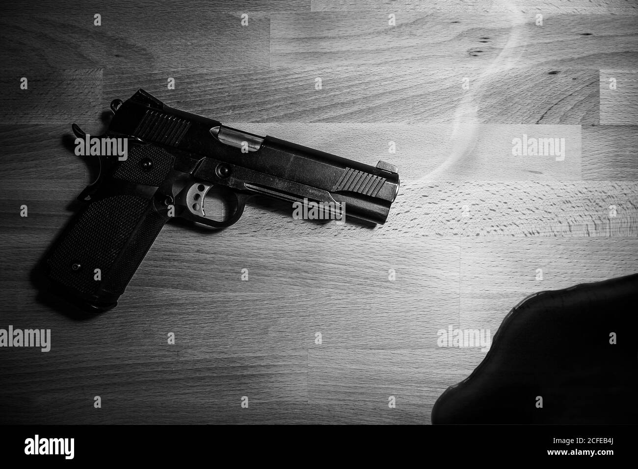 Gewehr und Blut auf Holztisch. Schwarz und weiß. Raub, Mord, Verbrechen und Sicherheitskonzept Stockfoto