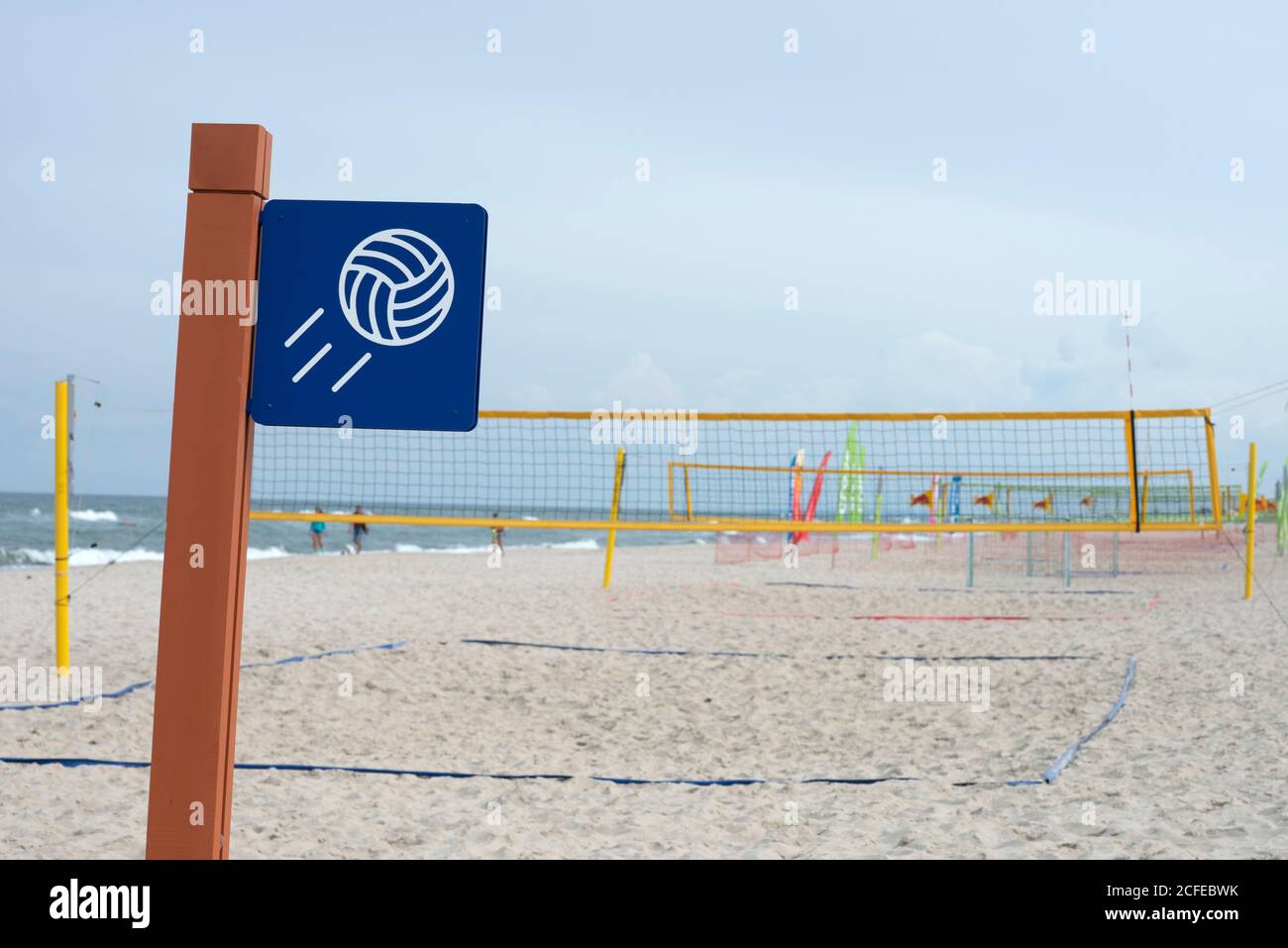 Beachvolleyball-Schild und Netz am leeren Strand Stockfoto