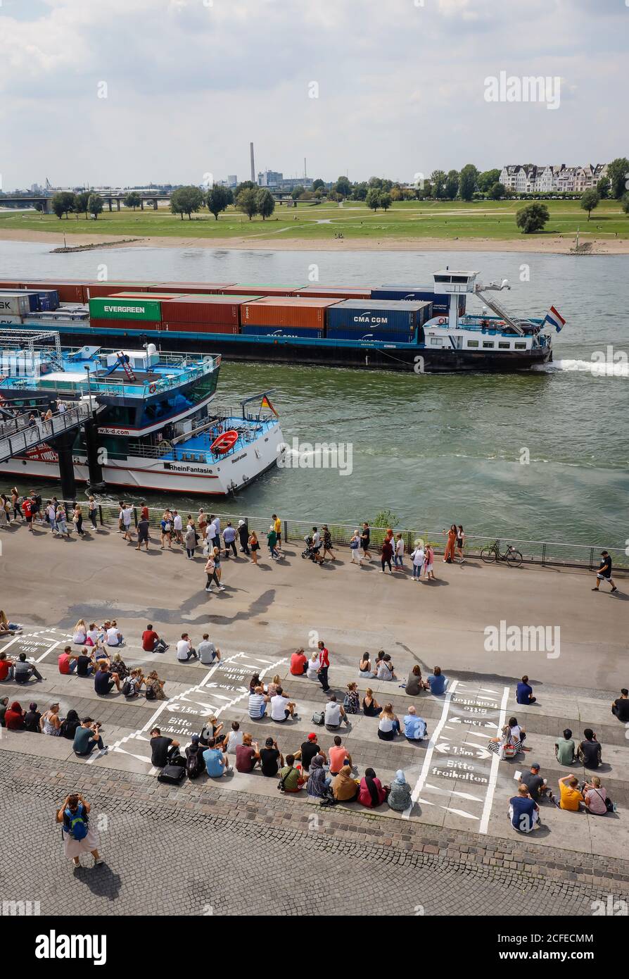 Düsseldorf, Nordrhein-Westfalen, Deutschland - Rheinpromenade in Zeiten der Coronapandemie sitzen Menschen auf der Rheintreppe am Burgplatz Stockfoto