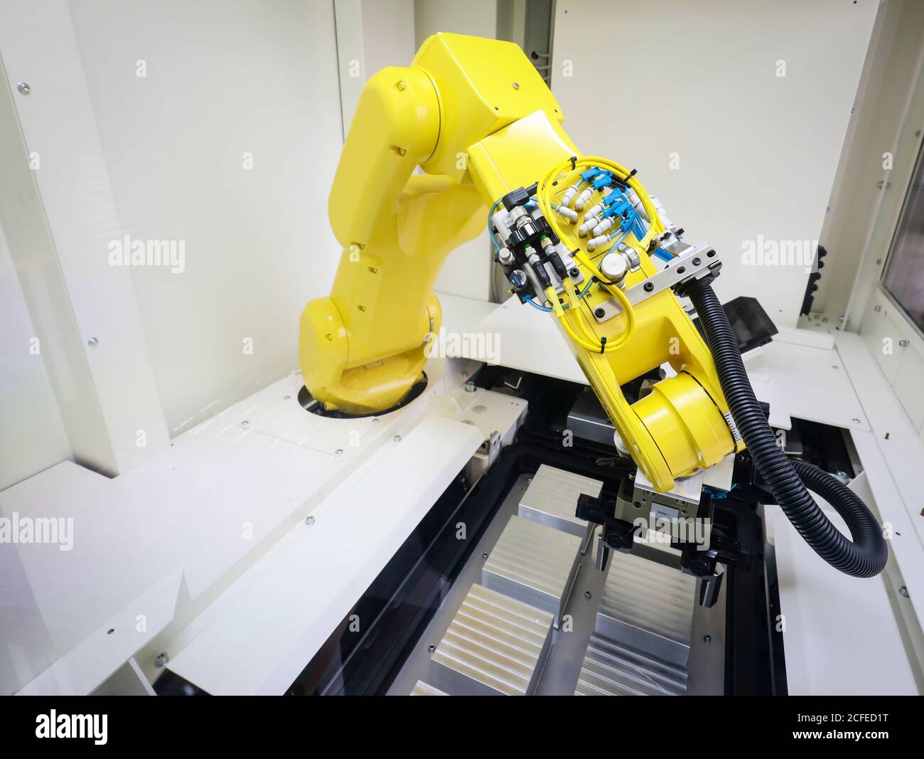 Bochum, Nordrhein-Westfalen, Deutschland - Roboterarm stattet hier bei Stromboli Elektro und Feinwerktechnik eine CNC-Fräsmaschine mit Werkstücken aus Stockfoto
