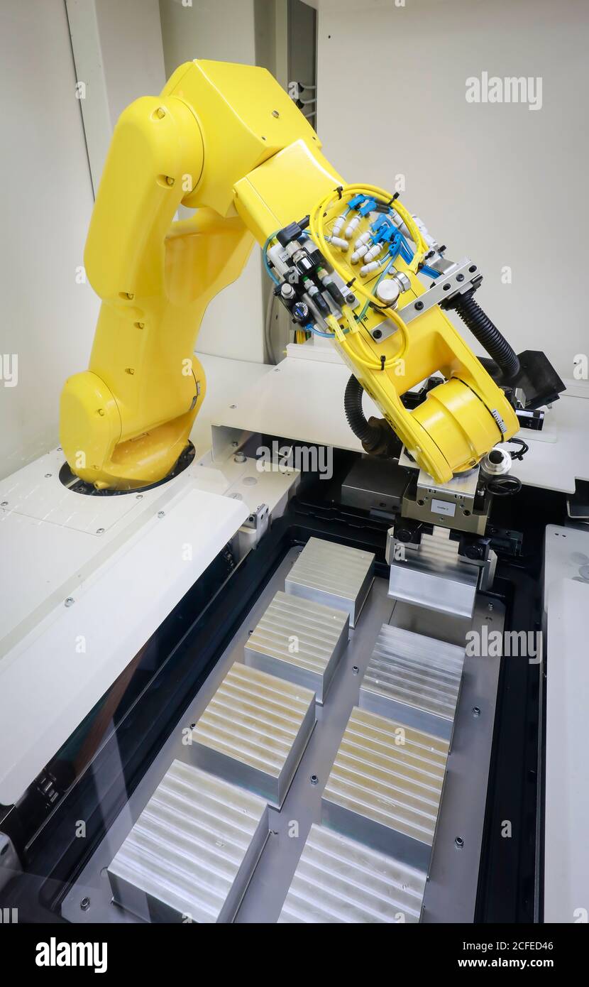 Bochum, Nordrhein-Westfalen, Deutschland - Roboterarm stattet hier bei Stromboli Elektro und Feinwerktechnik eine CNC-Fräsmaschine mit Werkstücken aus Stockfoto