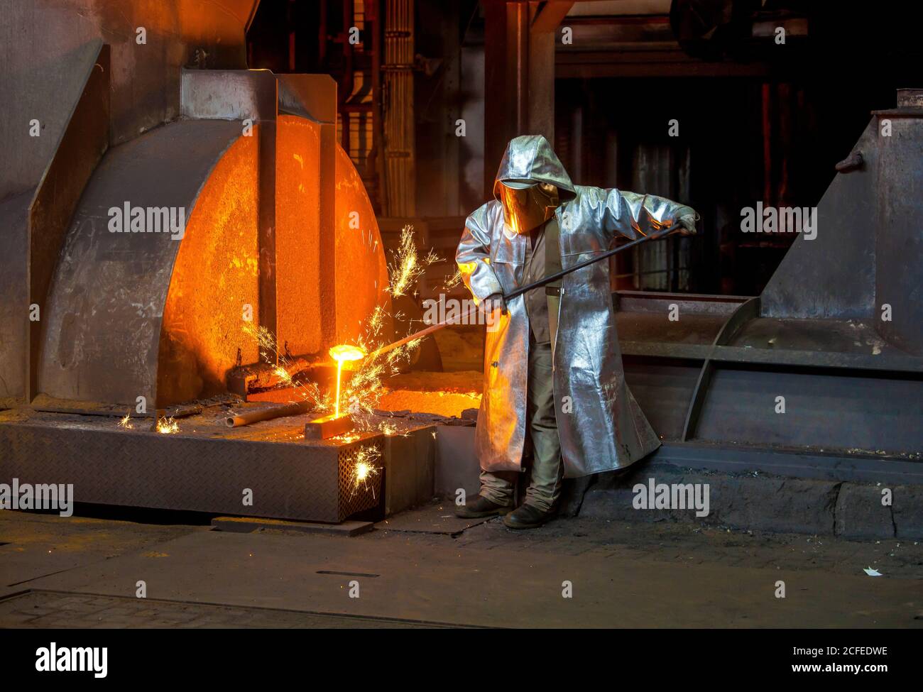 Duisburg, Ruhrgebiet, Nordrhein-Westfalen, Deutschland - ThyssenKrupp Steel, ein Stahlarbeiter im Schutzanzug, nimmt eine 1500-Grad-Heißmetallprobe Stockfoto