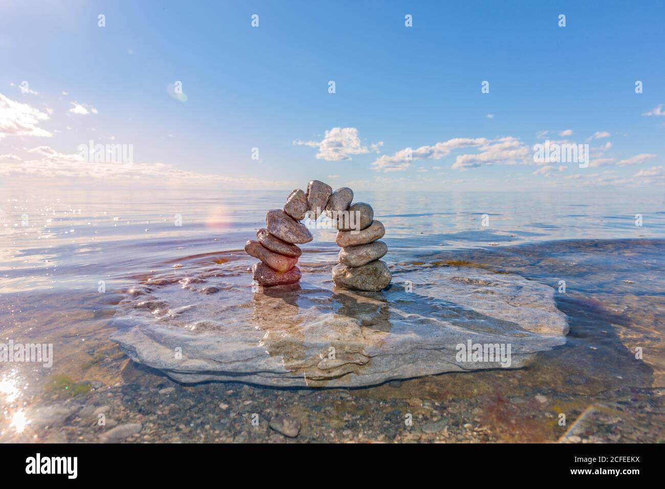 Steinbogen aus Kieselsteinen im Wasser Stockfoto