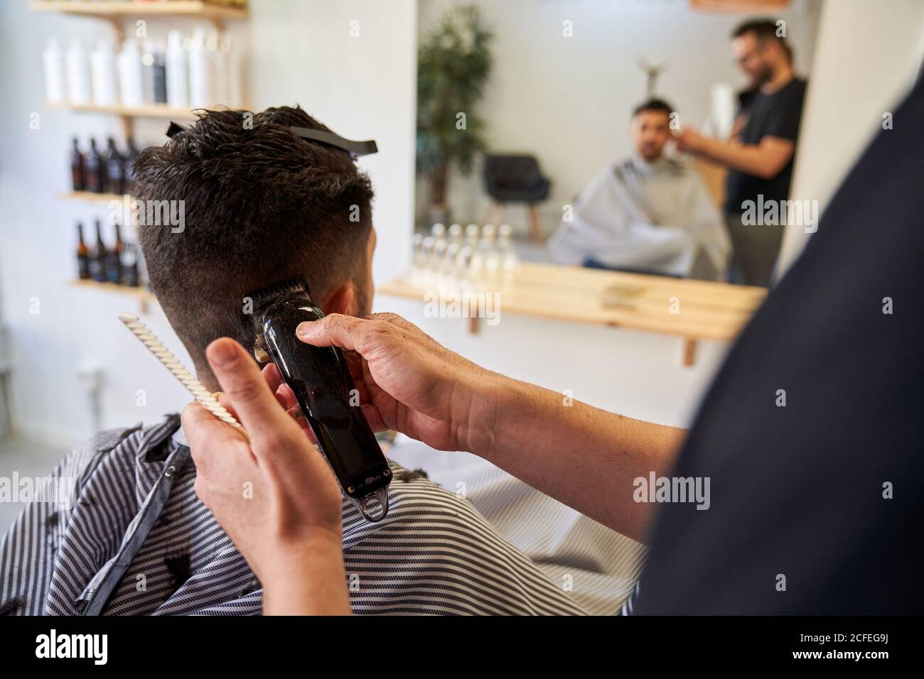 Stock Foto von einer Hand eines Barbiers schneiden Haare hinter den Ohren  eines Kunden mit einem Rasierer. Barbershop und Lifestyle Stockfotografie -  Alamy