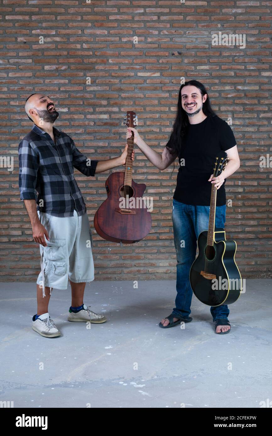 Glücklich Erwachsene Männer halten Gitarren Spaß in einer Leistung. Stockfoto