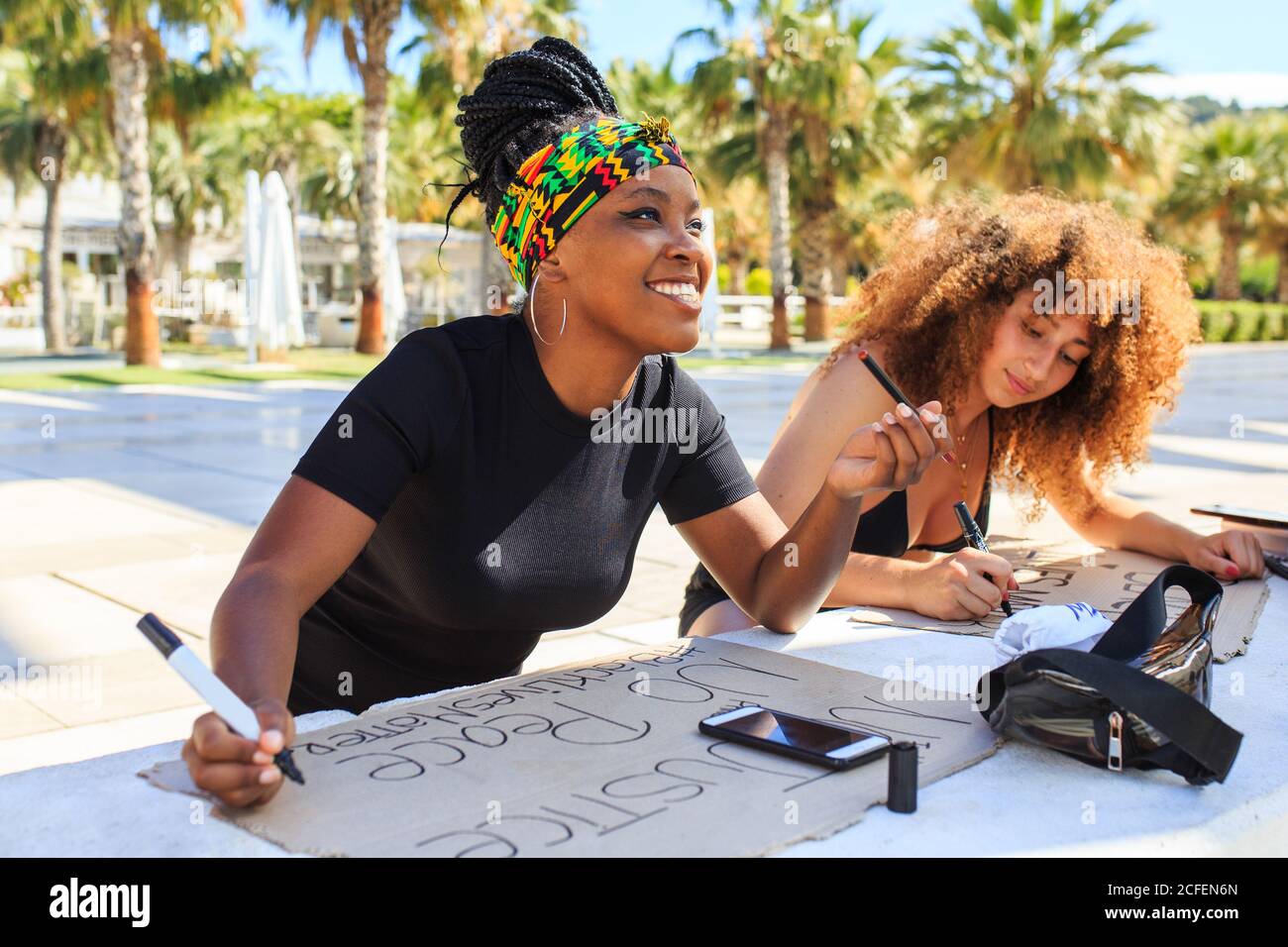 Diverse weibliche Aktivisten machen Plakate mit schwarzen Leben Materie und Keine Gerechtigkeit, keine Friedensinschriften während der Vorbereitung auf den Streik gegen Rassismus Stockfoto