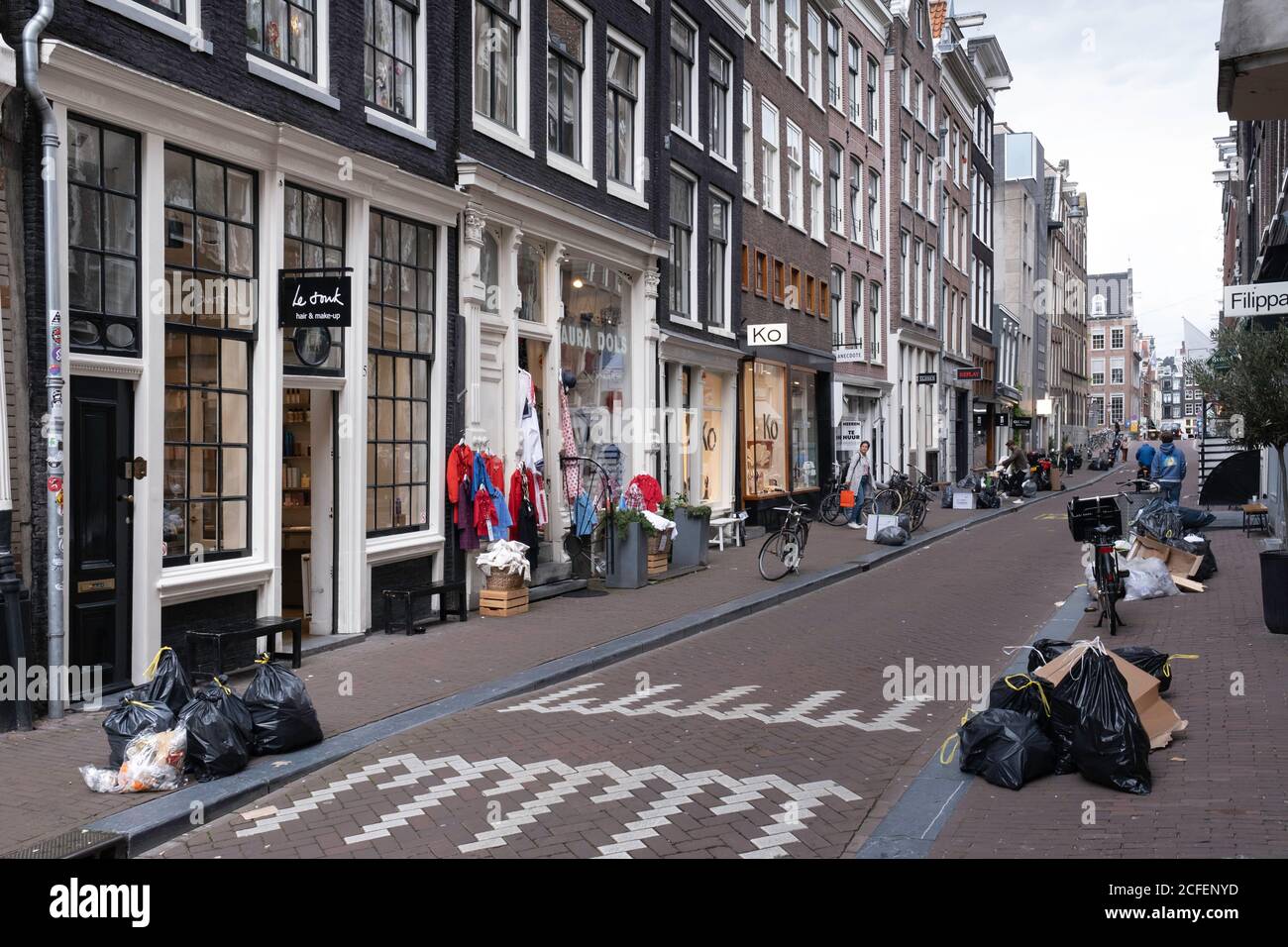 Müllsäcke liegen auf einer Straße in der Negen Straatjes (deutsch: Neun kleine Straßen), einem Viertel von Amsterdam, Niederlande Stockfoto