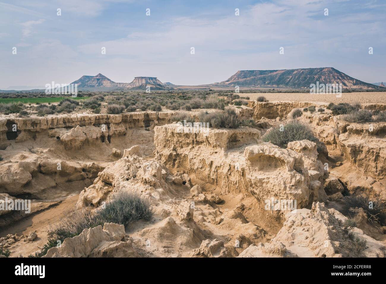 Erstaunliche Wüstenlandschaft mit geknackten felsigen Steinen trockene Vegetation und Hügel in Halbwüste Bardenas Reales Navarra Spanien Stockfoto