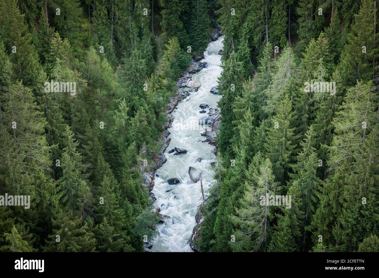 Von oben schnell schäumenden Fluss Bergbach rauscht durch Dutzende Von immergrünen Wäldern in der Schweiz Stockfoto
