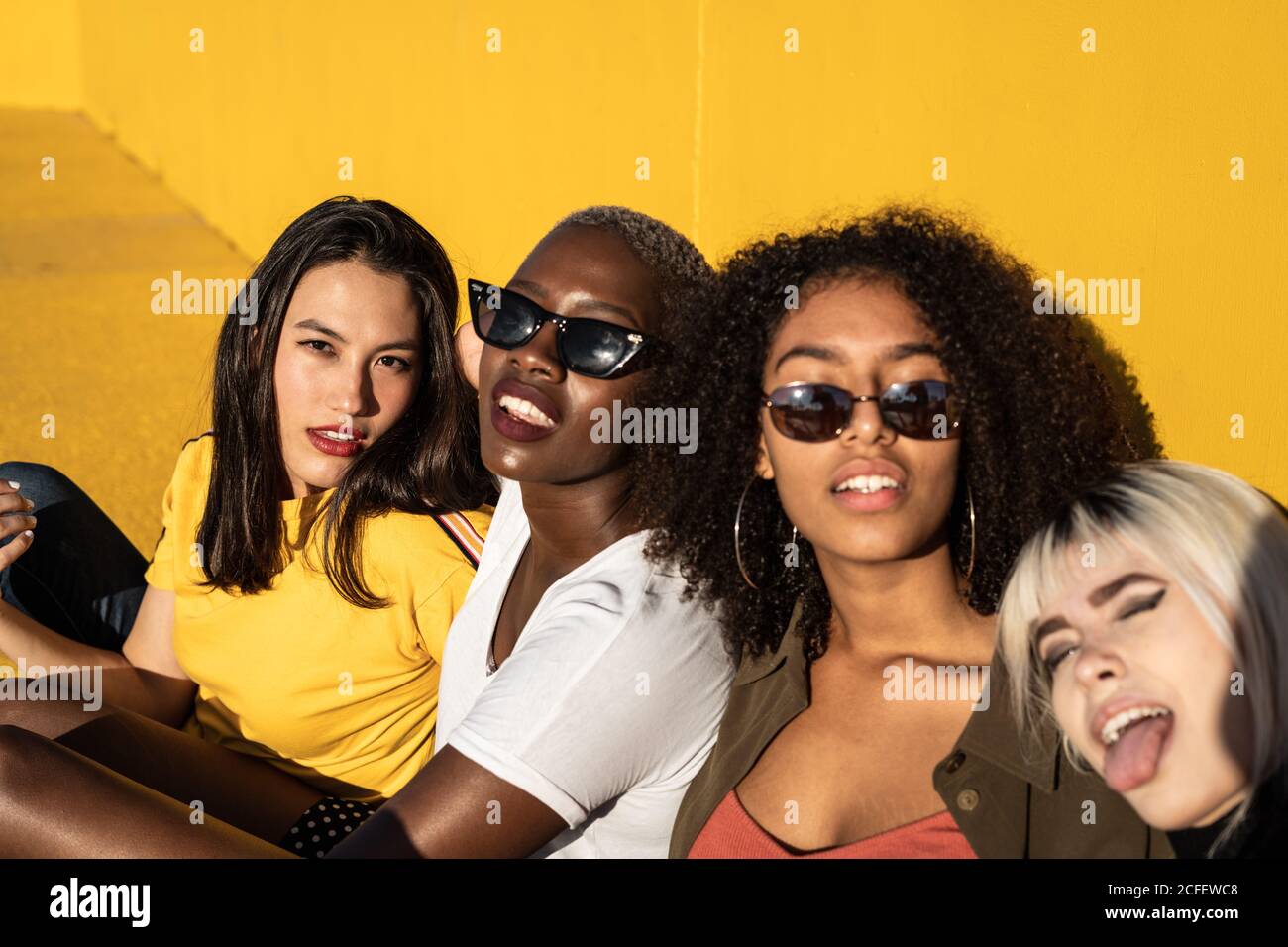 Fröhliche junge multirassische weibliche Studenten genießen Zeitvertreib im Stadion Stockfoto