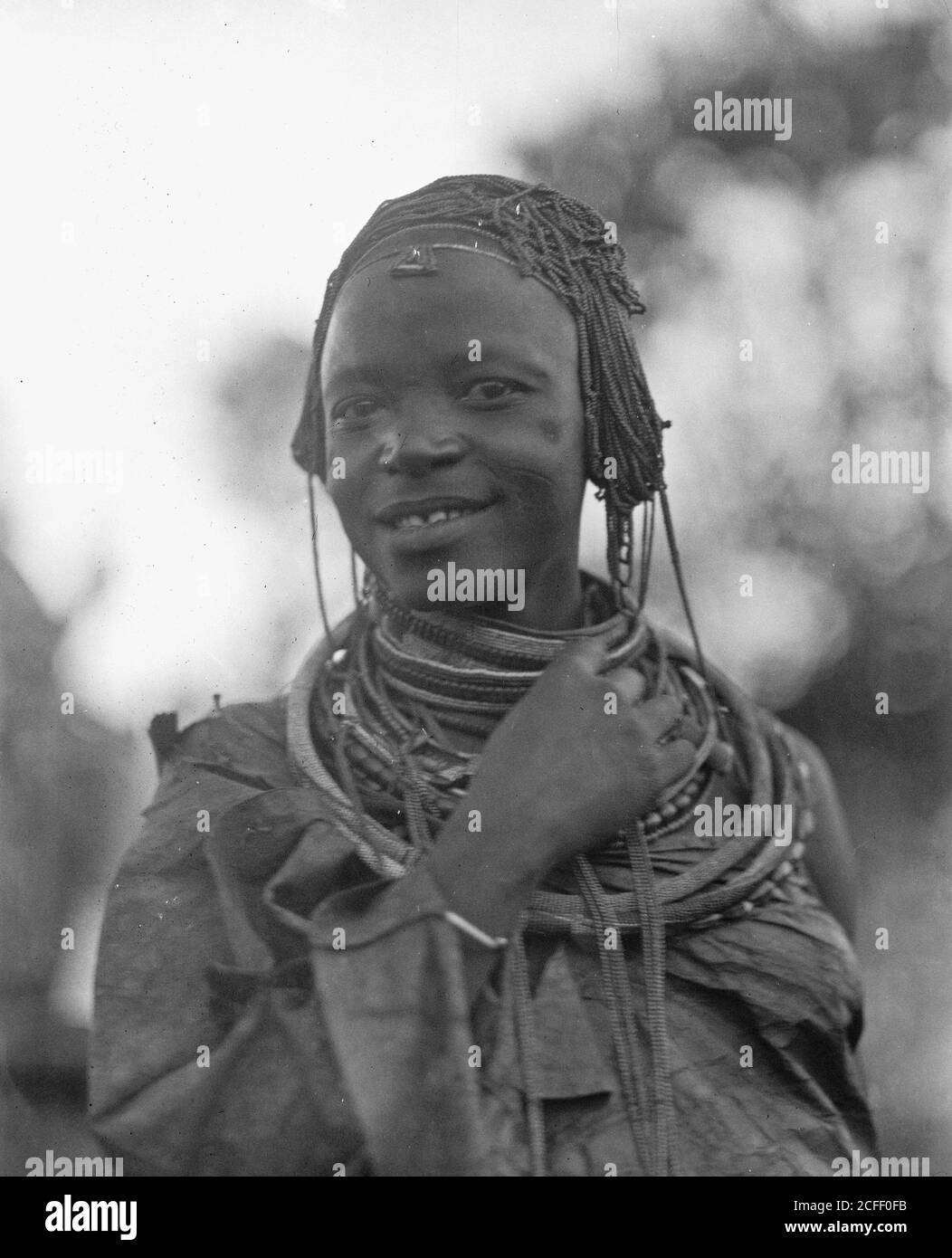 Originalunterschrift: Tanganjika. Auf dem Weg nach Longido. Tanganjika Mädchen mit Perlen Kopfbedeckung - Ort: Tansania ca. 1936 Stockfoto