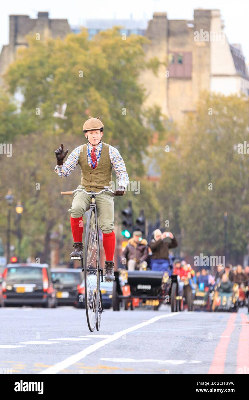 Ein Teilnehmer radelt auf einem Penny Farthing oder High Wheel bei Bonhams London zum Brighton Veteran Car Run in Westminster, London, England Stockfoto
