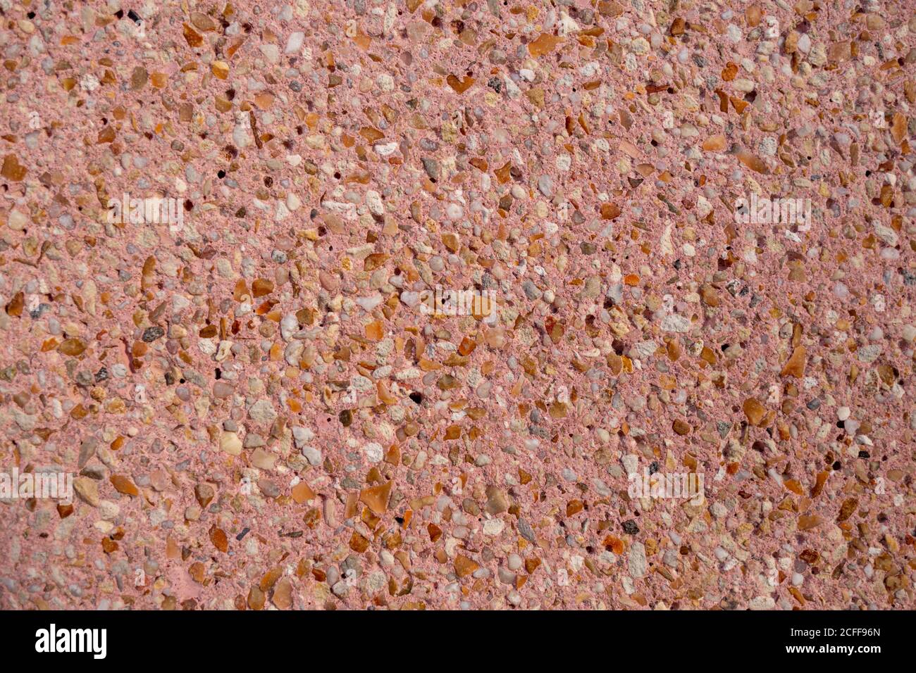 Dekorative Wand mit kleinen Steinen in rosa Zement Stockfoto