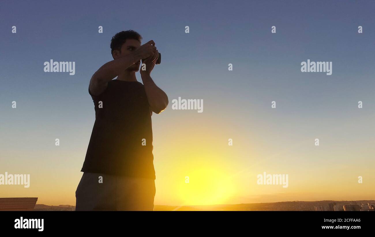 Silhouette eines Fotografen, der Bilder auf dem aufnimmt Gebäude bei Sonnenuntergang Stockfoto