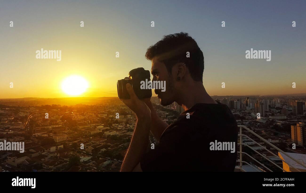 Silhouette eines Fotografen, der Bilder auf dem aufnimmt Gebäude bei Sonnenuntergang Stockfoto
