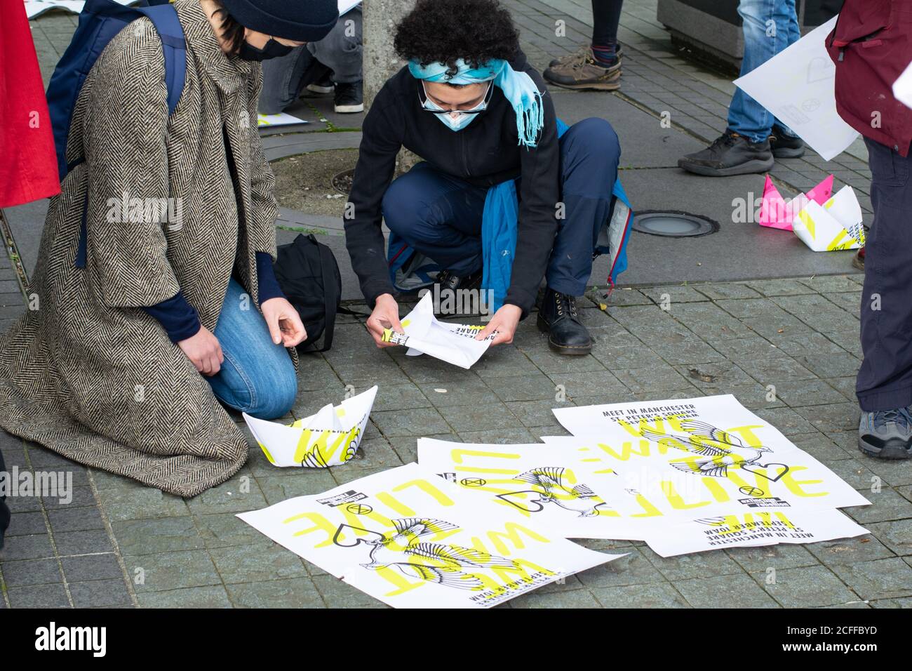 Extinction Rebellion befreit die Wahrheit Protest in Media City, Salford Quays. Protester macht Papierboot mit alten Plakat. Stockfoto