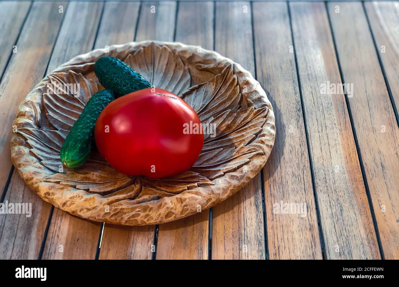 Tomate und cucumberы auf Holzplatte Löffel und Gabel Set. Frisches Bio-Gemüse und Obst gesundes Essen von Mutter Farm Konzept. Stockfoto