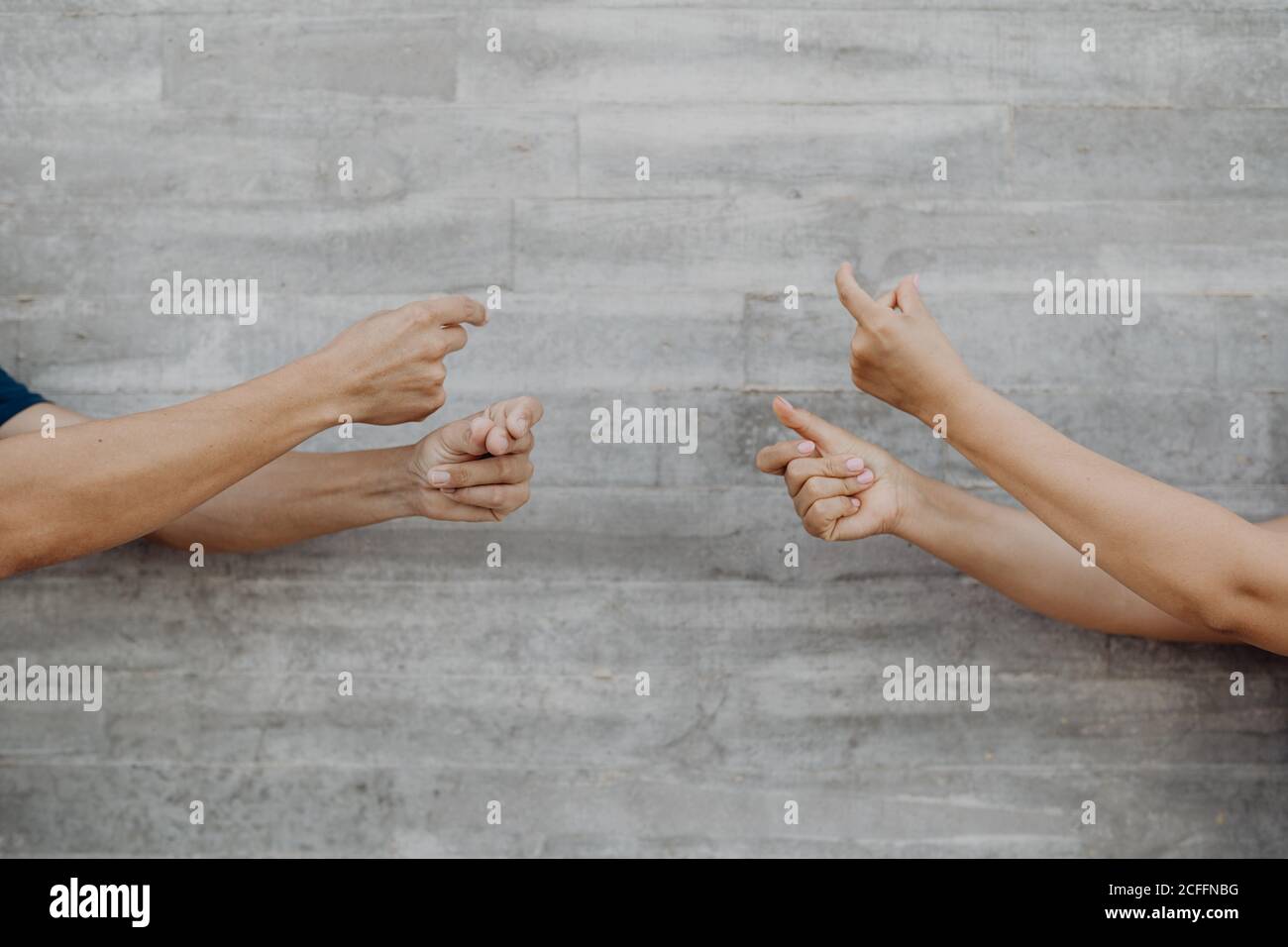 Gebräunte starke Hände von Crop Mann und Frau gestikulieren mit Musik an der grauen Wand Stockfoto