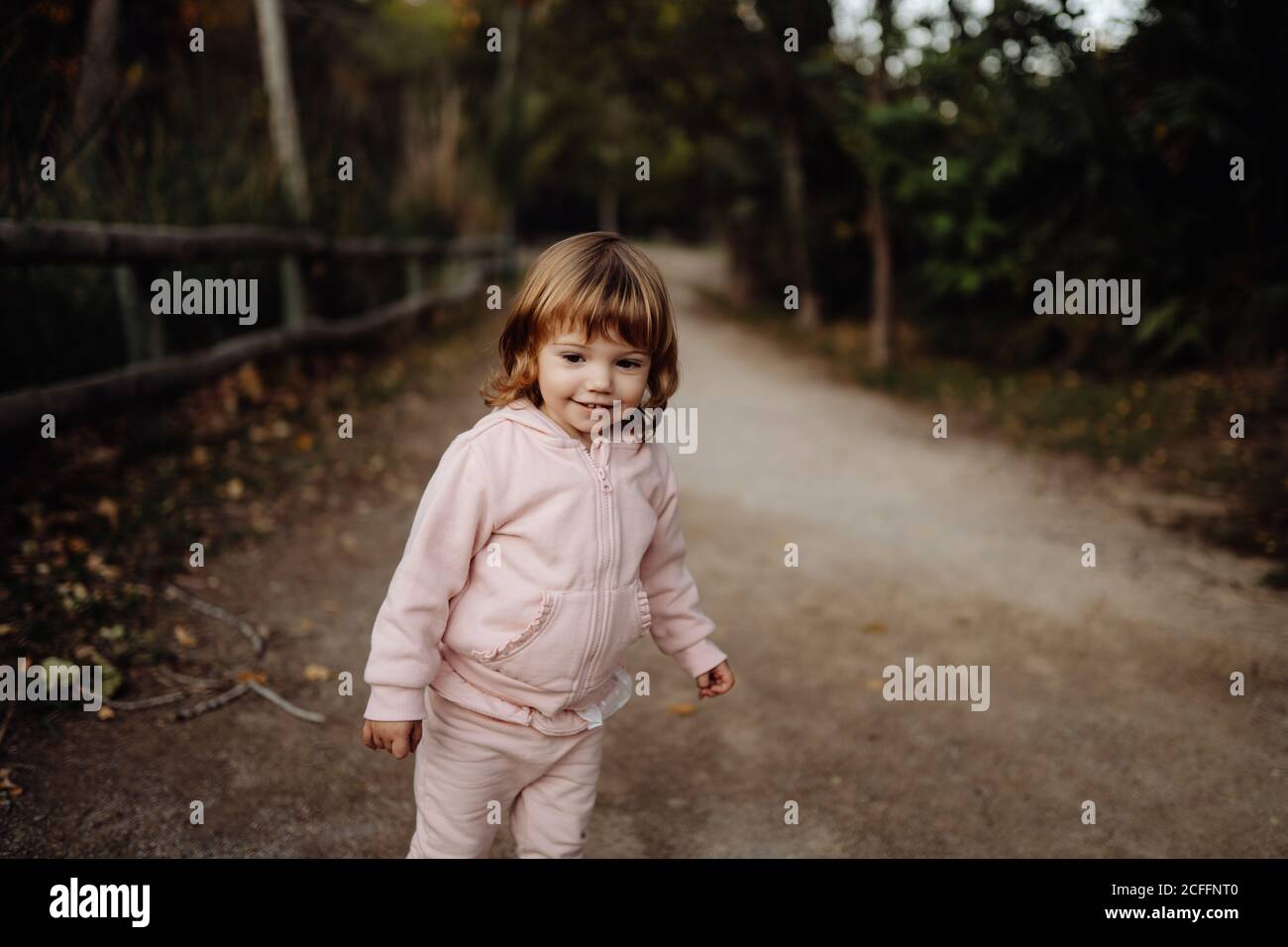 Adorable aktiv Kind in warmen rosa Jacke im Sonnenlicht in parken Stockfoto