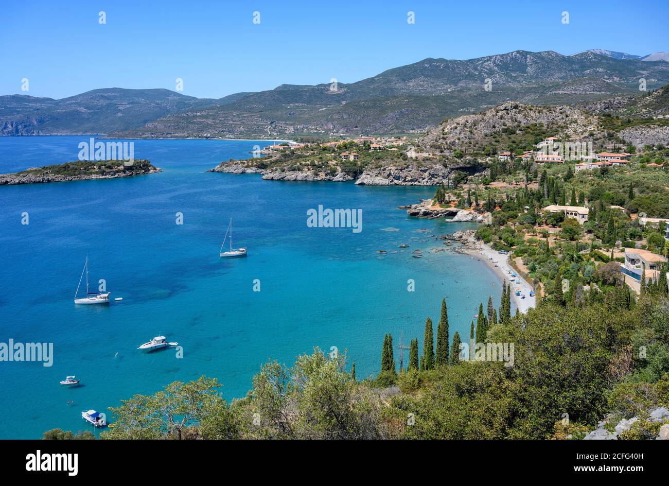 Yachten in Kalamitsi Bucht mit der Ortschaft Kardamiyli im Hintergrund festgemacht, Messenischen Mani, dem südlichen Peloponnes, Griechenland. Stockfoto