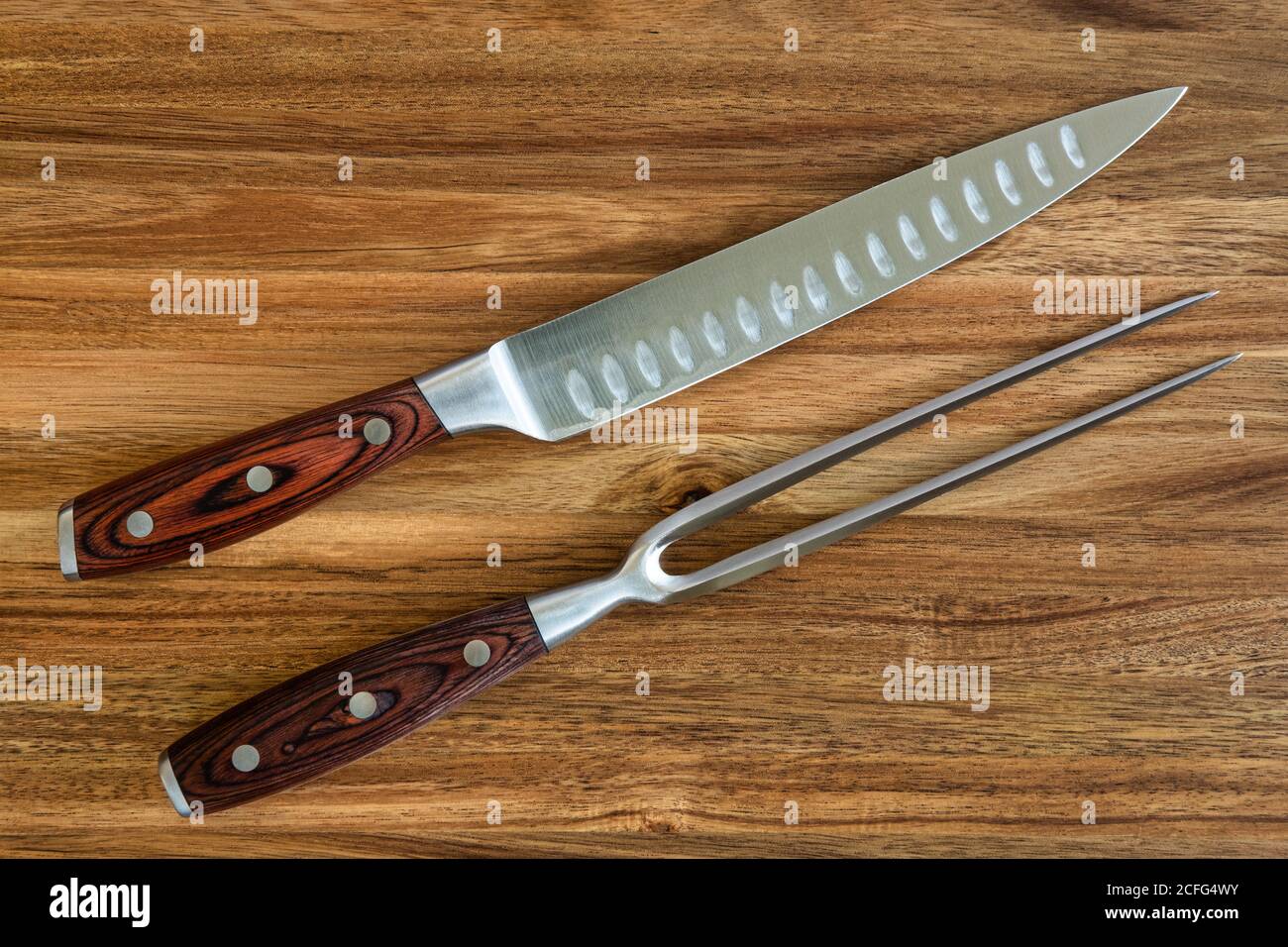 Foto von Messer und Gabel Schnitzerei auf einem Holz gesetzt Schneidebrett Stockfoto
