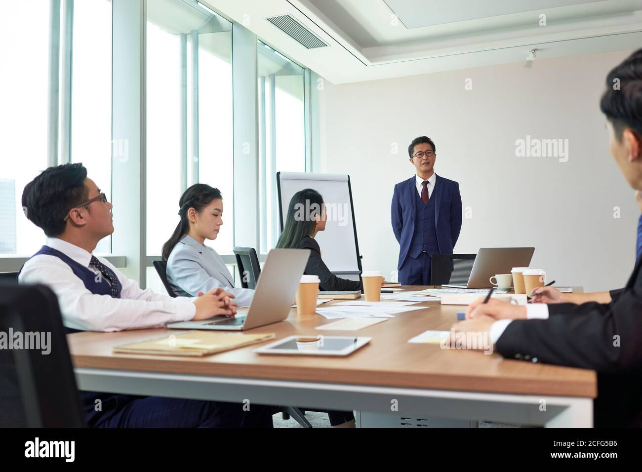 asiatischer Chef hält eine Rede während eines Meetings in der Firmenkonferenz Zimmer Stockfoto
