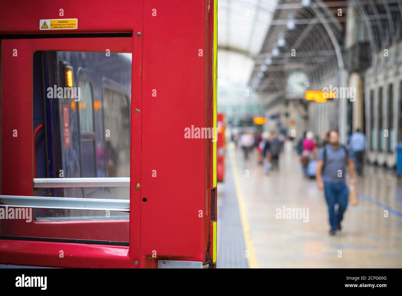 Wählen Sie Fokus, Zugtür mit verschwommenen Passagieren im Hintergrund am Bahnhof London Paddington Stockfoto