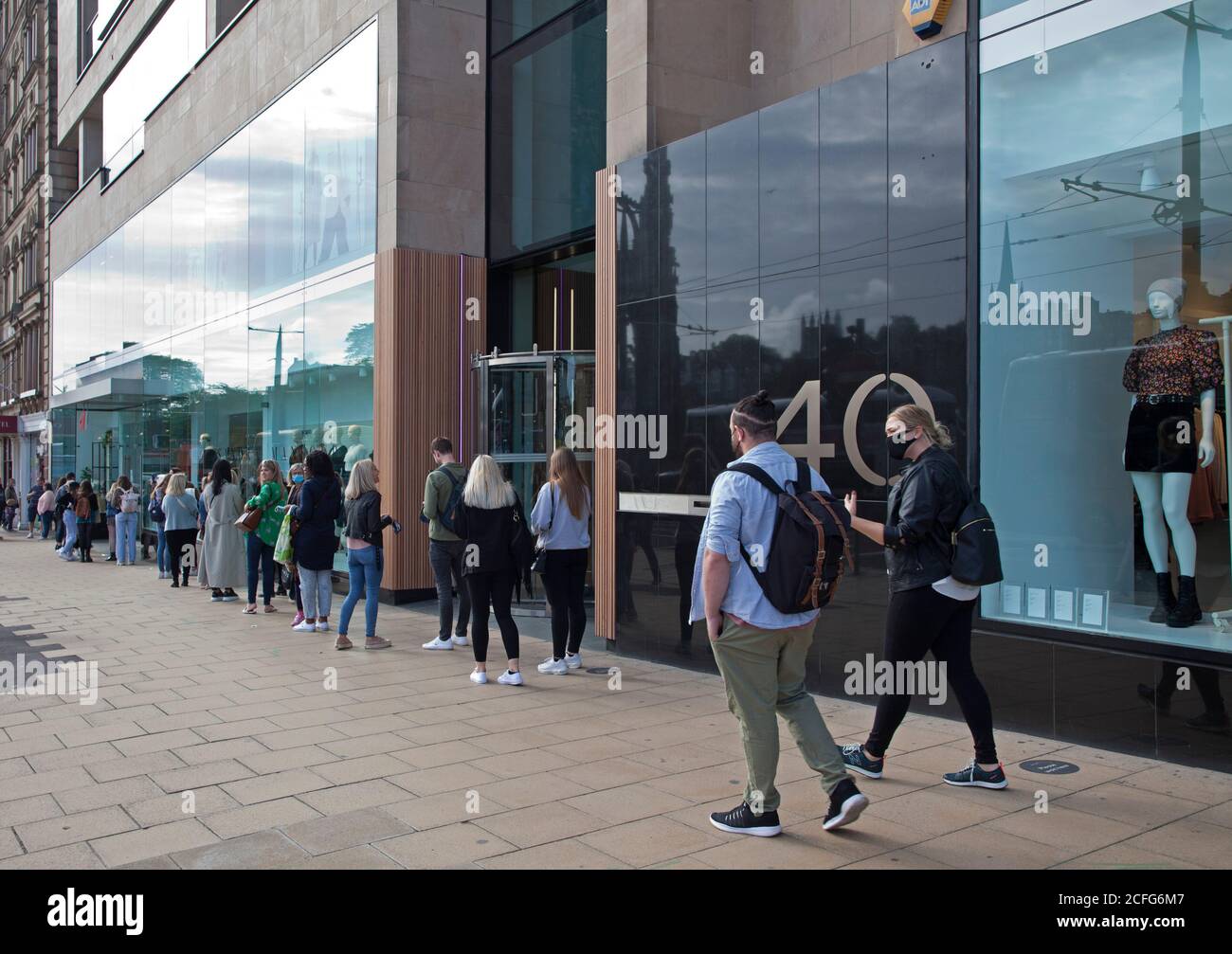 Edinburgh, Schottland, Großbritannien. September 2020. Princes Street Geschäfte lange gesellschaftlich distanzierte Warteschlangen vor den Geschäften am Samstagnachmittag. Im Bild stehen junge Leute vor H&M. Quelle: Arch White/ Alamy Live News. Stockfoto