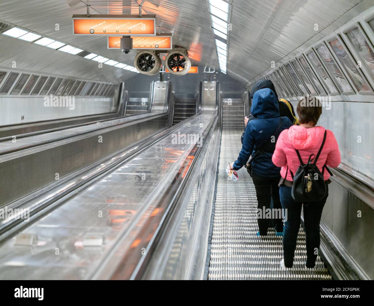 Tiefe U-Bahn in Budapest: Zugfahrer nehmen eine sehr lange Rolltreppe tief unter der Stadt, um das effiziente öffentliche Verkehrssystem in der Stadt Budapest zu fahren. Stockfoto