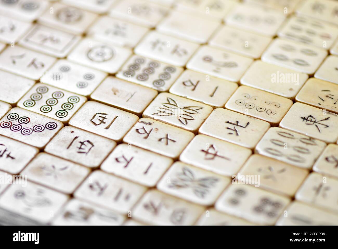 Nahaufnahme von alten Mahjong-Kacheln mit chinesischer Schrift in Eine schräge Winkelansicht mit selektivem Fokus zur Mitte Stockfoto