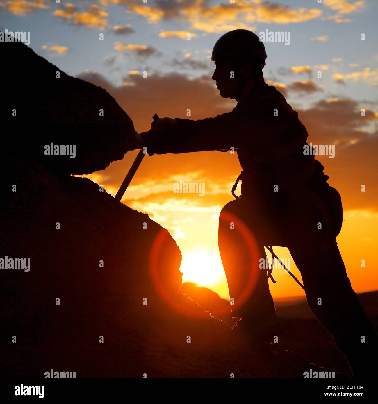 Climber Silhouette gegen bewölkten Sonnenuntergang Stockfoto