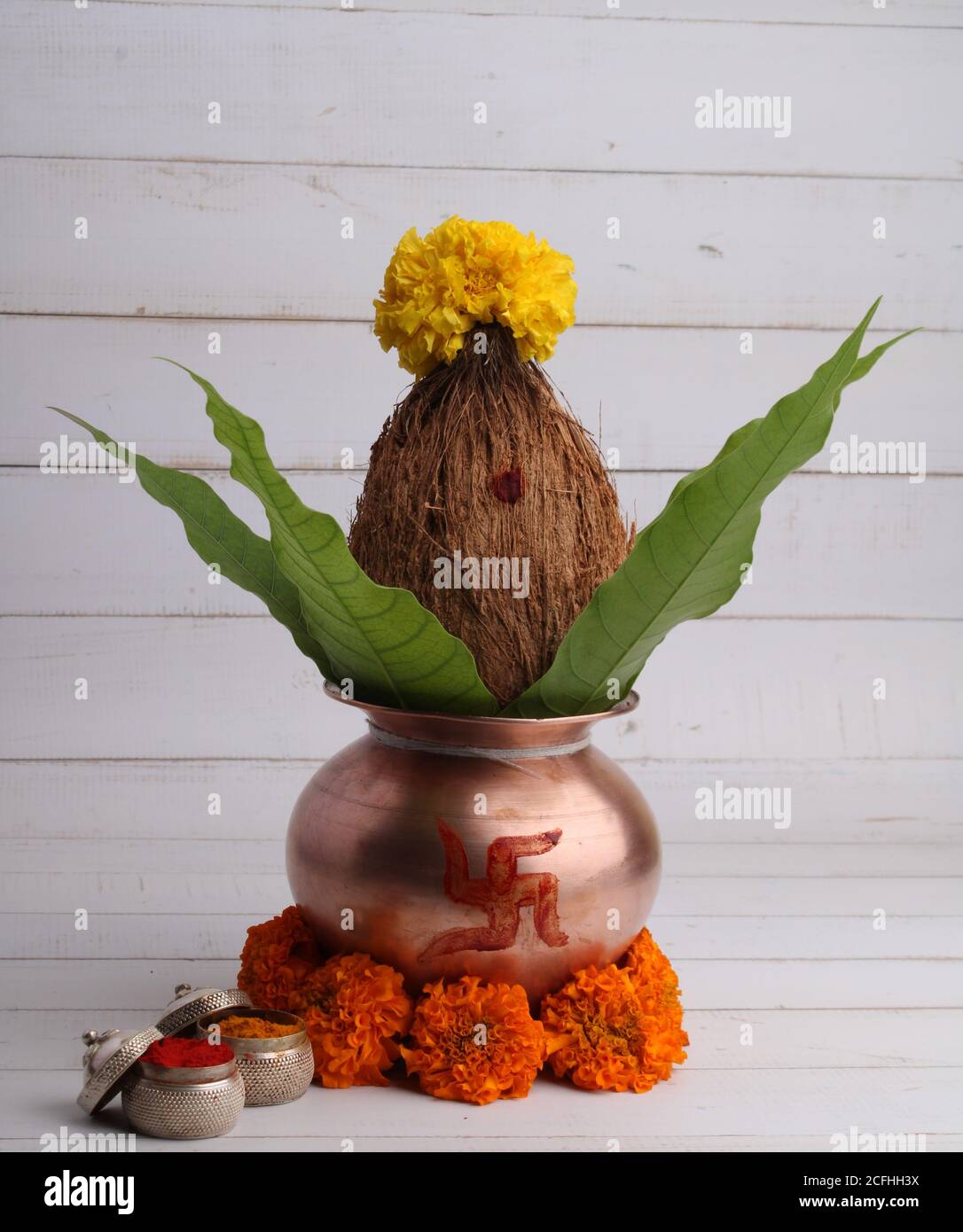 Kupfer kalash mit Kokos- und Mangoblatt mit haldi Kumkum und Blumenschmuck. Unverzichtbar in hindu Puja. Stockfoto