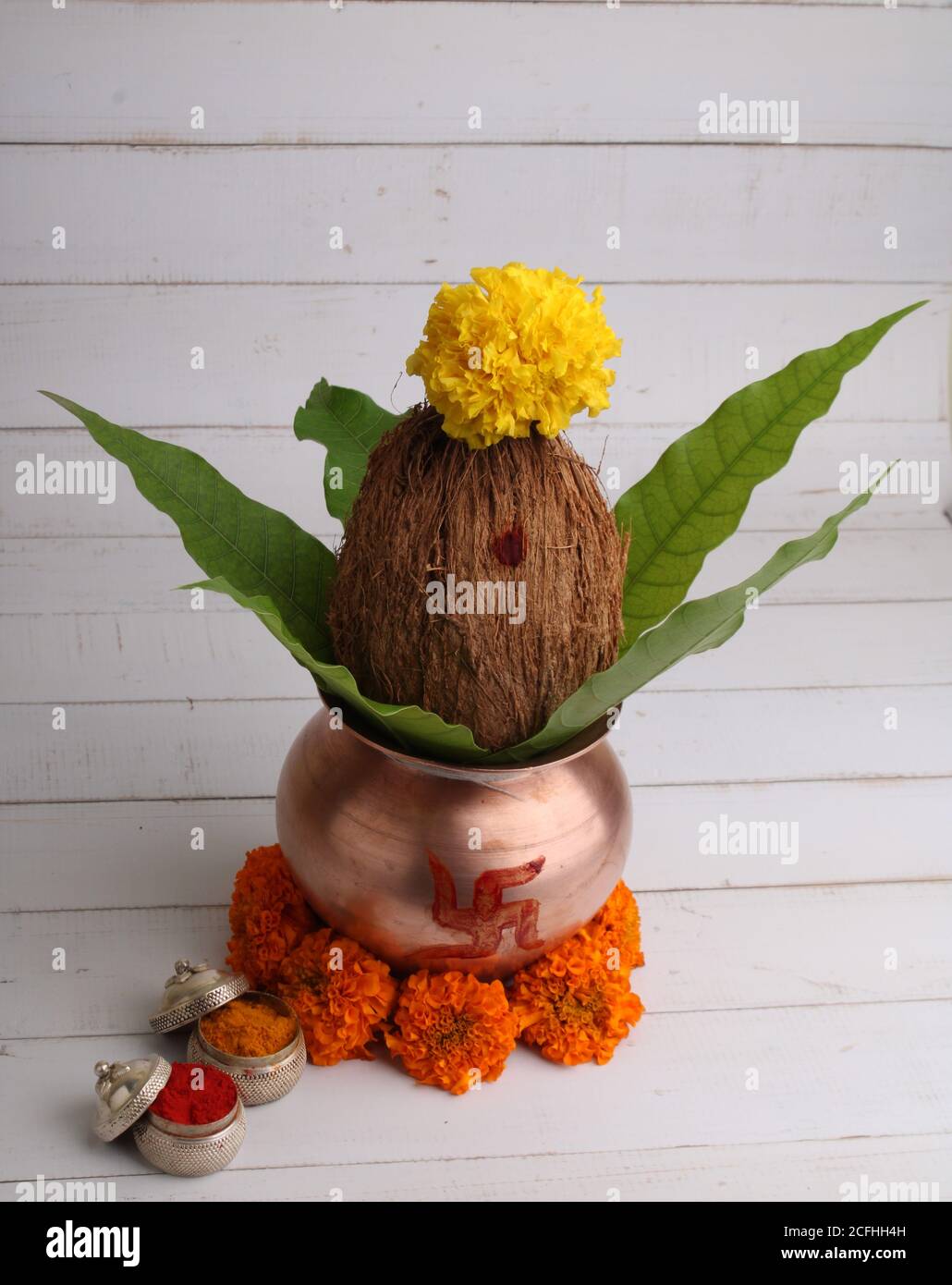 Kupfer kalash mit Kokos- und Mangoblatt mit haldi Kumkum und Blumenschmuck. Unverzichtbar in hindu Puja. Stockfoto