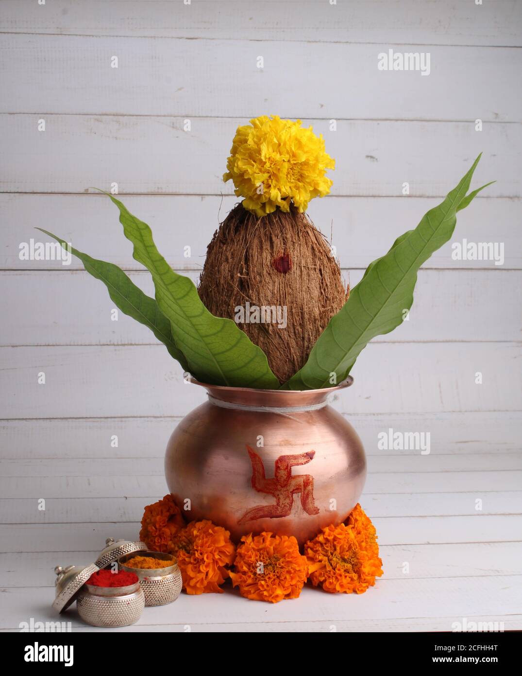 Kupfer kalash mit Kokos- und Mangoblatt mit haldi Kumkum und Blumenschmuck. Unverzichtbar in hindu Puja. Stockfoto