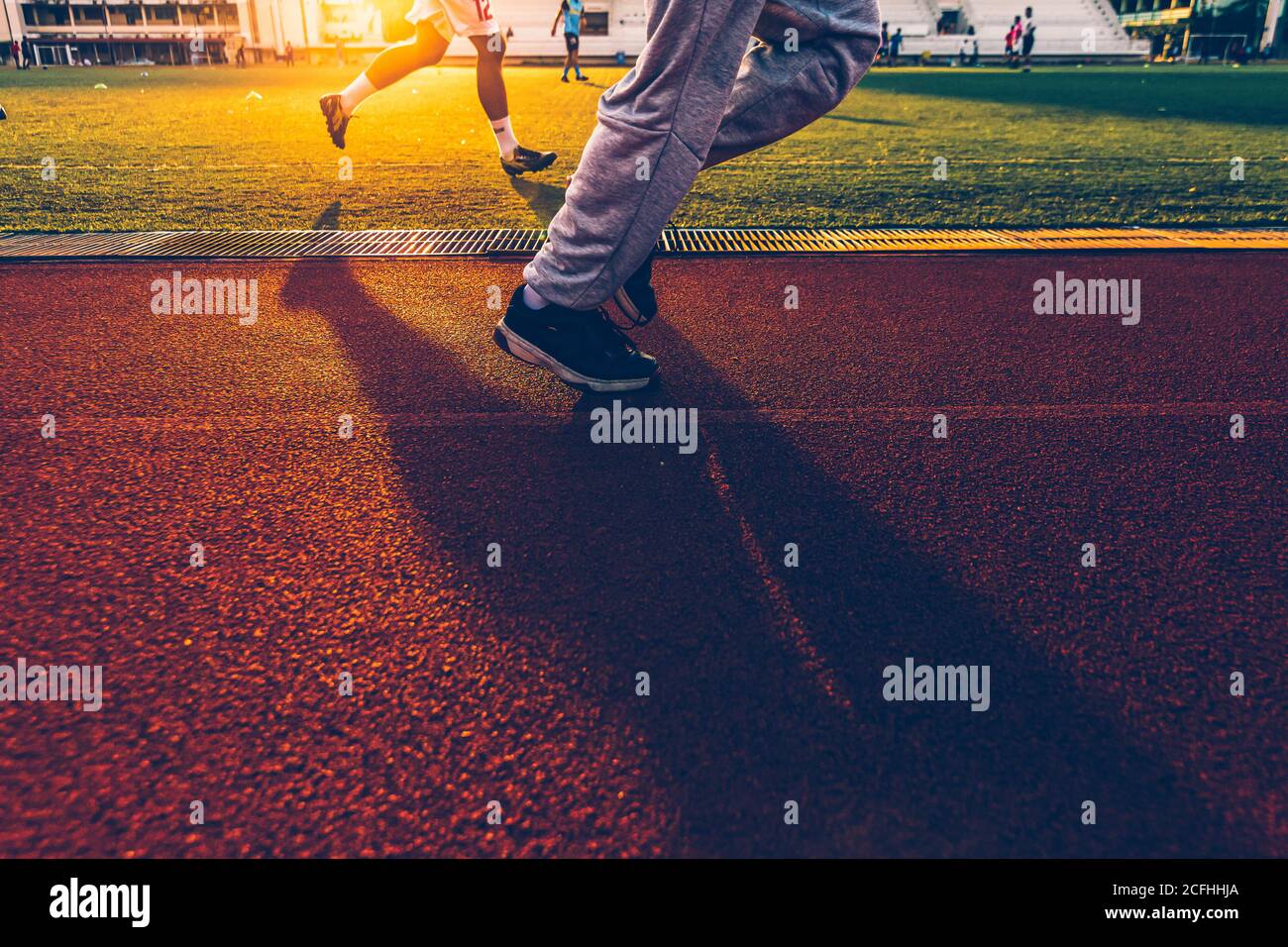 Sport man Joggen und Laufen auf der Strecke Rennen im Stadion mit Sonnenuntergang.Sportkonzept. Stockfoto