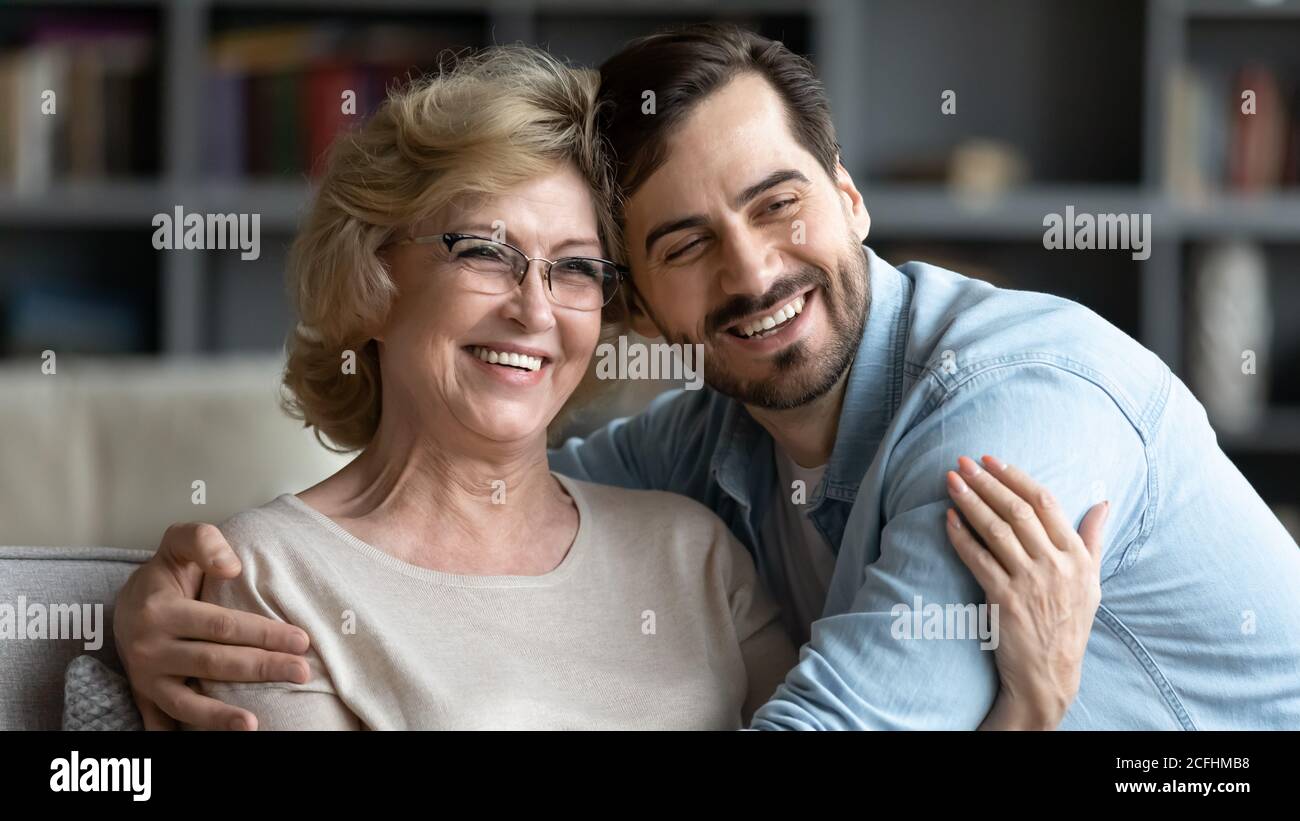Überglücklich reife Frau und erwachsenen Sohn umarmt, posiert für Foto Stockfoto