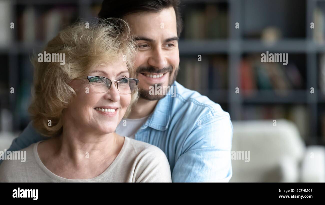 Nahaufnahme lächelnder junger Mann und reife Mutter träumen zusammen Stockfoto