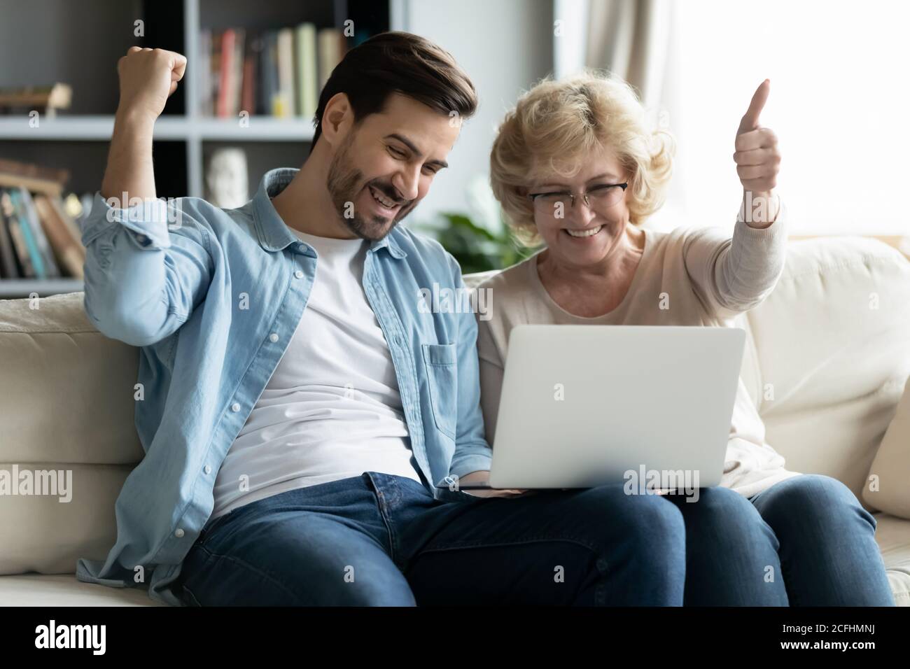 Überglücklich reife Frau und junger Mann Blick auf Laptop-Bildschirm Stockfoto
