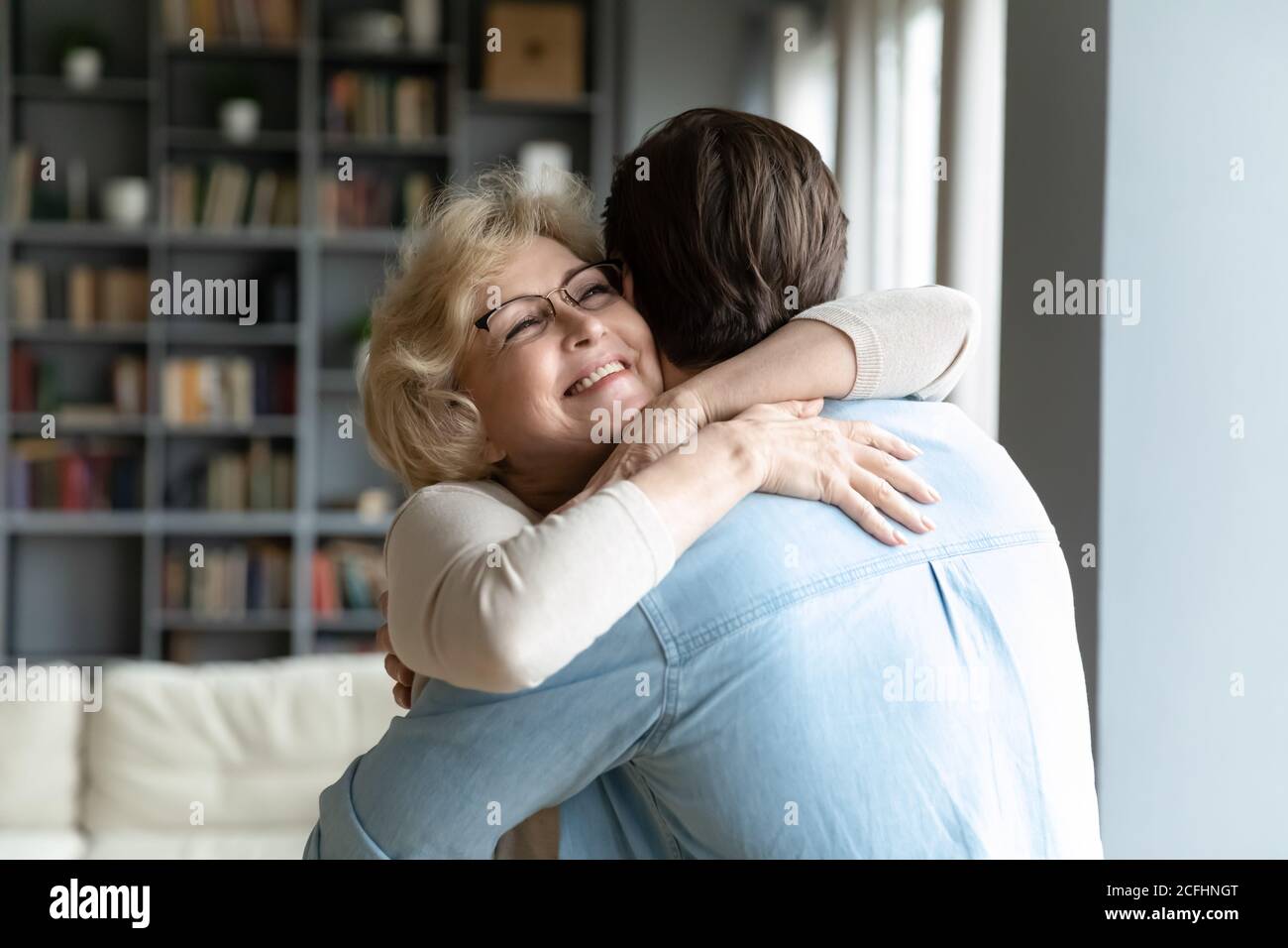 Nahaufnahme lächelnd reife Frau trägt Brille umarmt erwachsenen Sohn Stockfoto