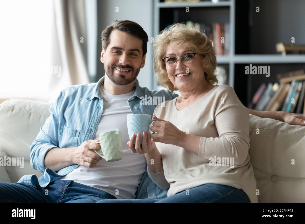 Kopf erschossen Porträt lächelnder Mann mit reifen Mutter trinkt Tee Stockfoto