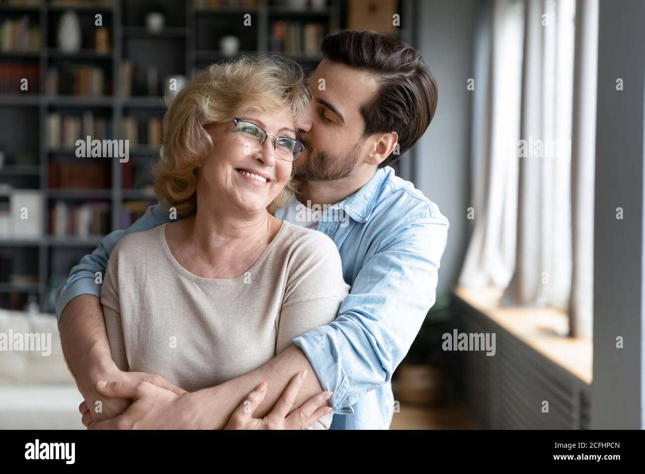 Liebevolle Erwachsene Sohn küssen und umarmen glücklich reife Mutter Stockfoto