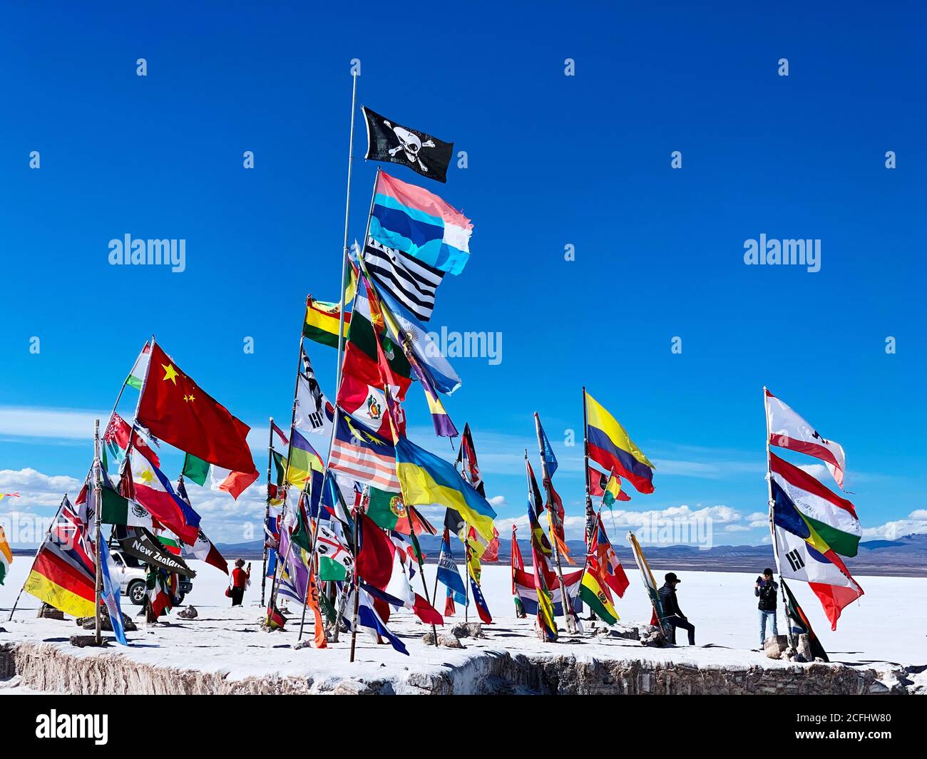 Bunte internationale Flaggen in der weißen, salzhaltigen Wüste Salar de Uyuni, Bolivien. Stockfoto