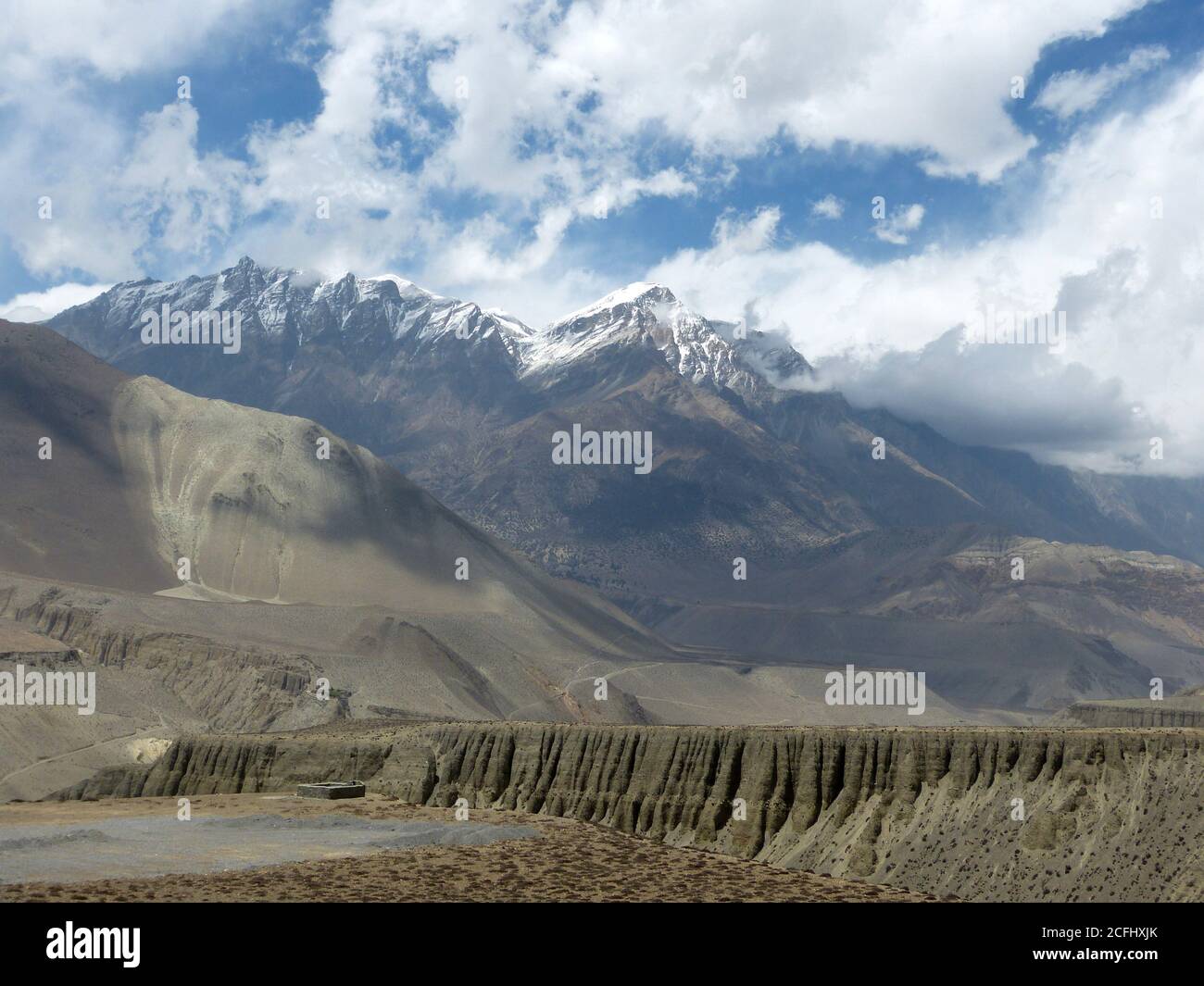 Landschaft der Himalaya-Berge in Nepal, Mustang Bezirk. Herrliche Klippenkette. Erstaunliche tibetische Landschaft aus Bergen, weißen Wolken, blauem Himmel. Stockfoto