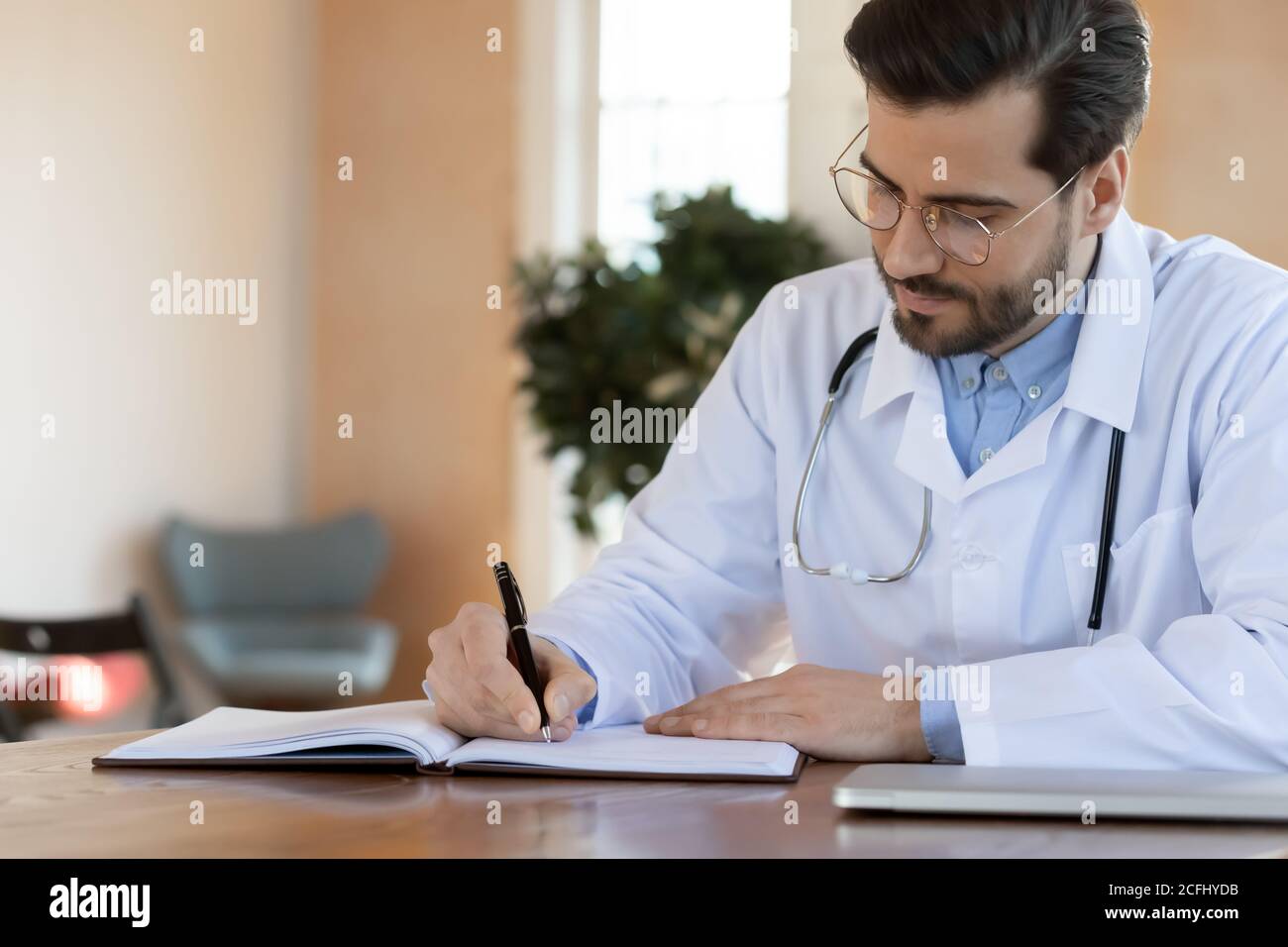 Serious zuversichtlich Arzt schriftlich in Dokumenten, arbeiten im Büro Stockfoto