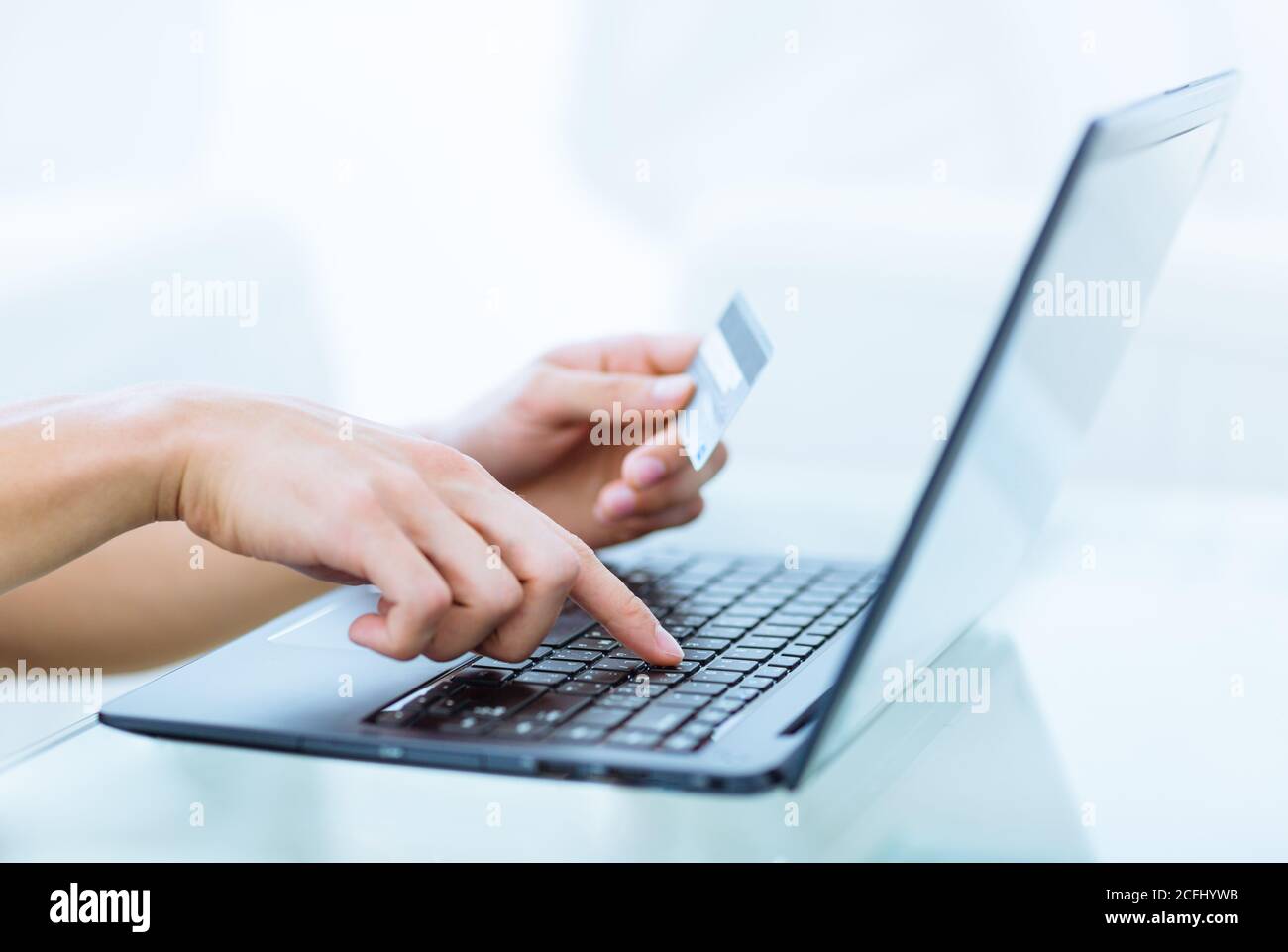 Online-Buchung Zahlung und Banking-Transaktion. Nahaufnahme der Hände einer Person, die eine Kreditkarte hält und Kontoinformationen auf einem Laptop-Computer eingibt. Stockfoto