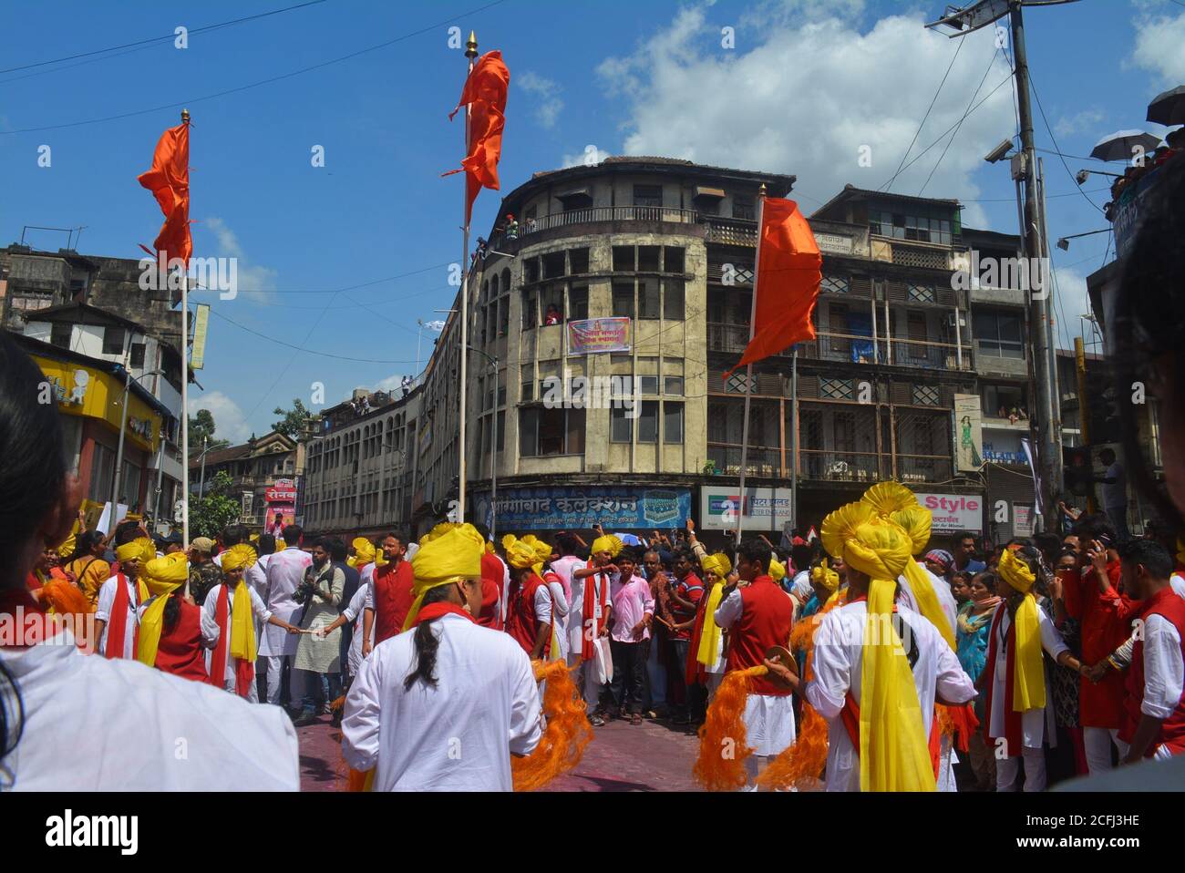 Pune, Indien - 4. September 2017: Dhol tasha pathak tanzt mit drei orangefarbenen Fahnen und feiert das Ganapati visarjan Festival. Dhol tasha pathak auf der Straße Stockfoto